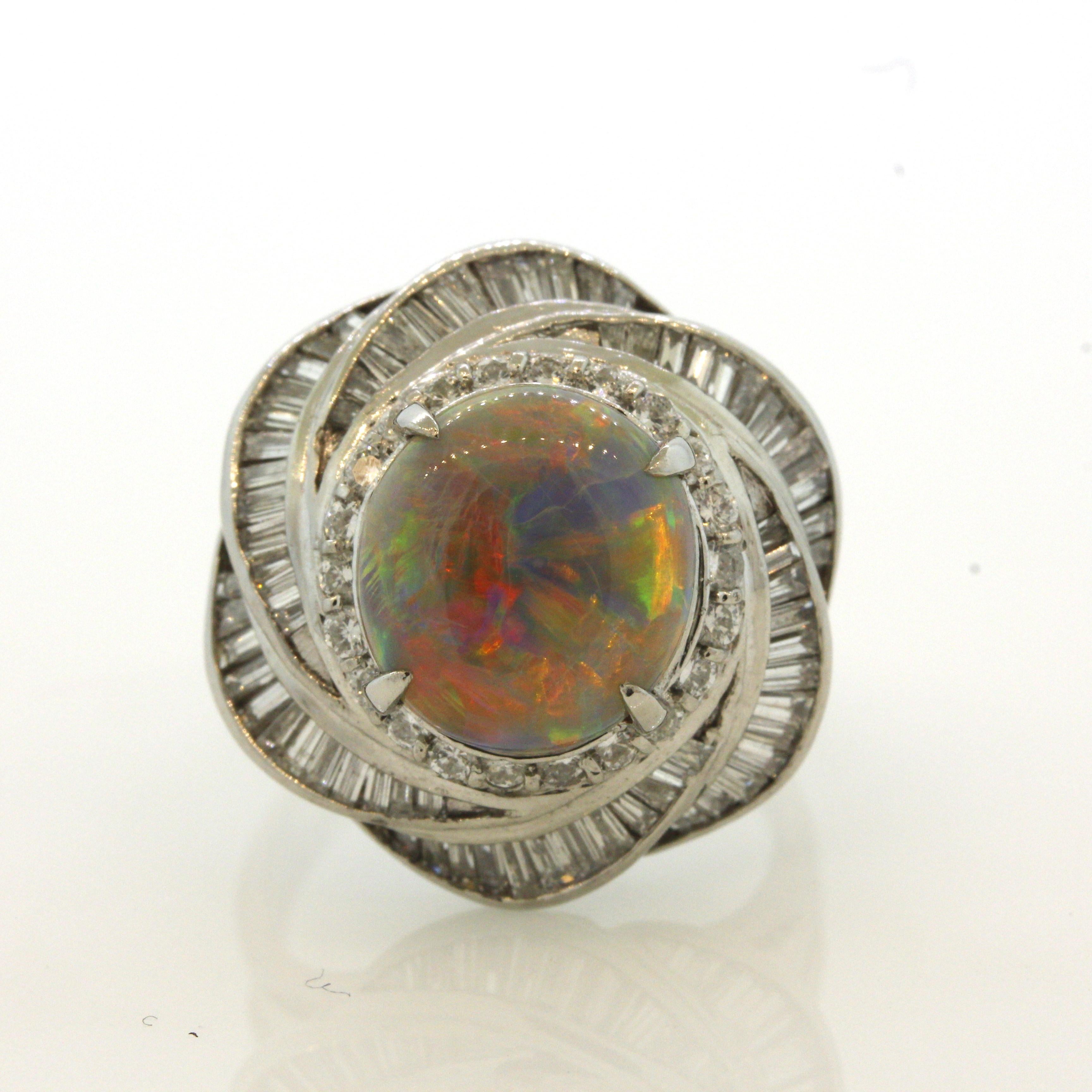 A mesmerizing fine natural Australian opal takes center stage. It weighs 3.92 carats and has amazing play-of-color, every color in the rainbow can be seen across the stone! Bright flashes of predominantly red and orange cover the opal along with