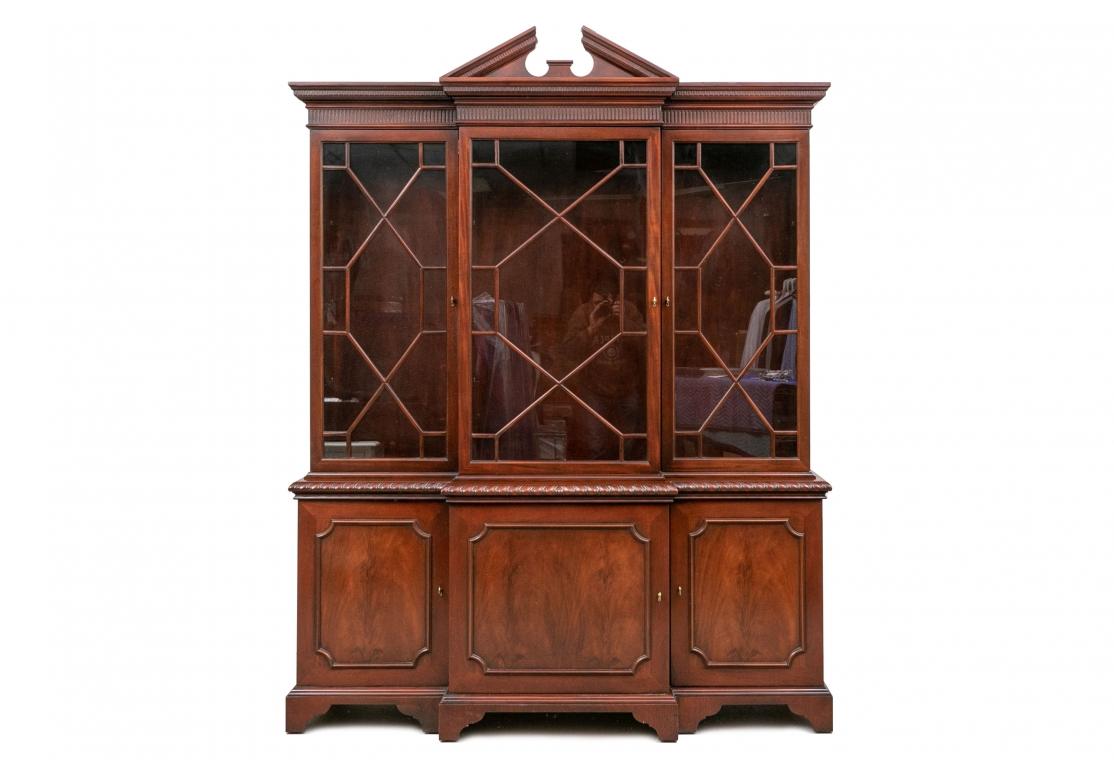 A fine Breakfront from Baker Furnitures famed Historic Charleston Collection. The lower case with carved gadrooned band over three doors with carved shaped moldings. The center door opens to a lined frieze drawer for silver. The side doors open to a