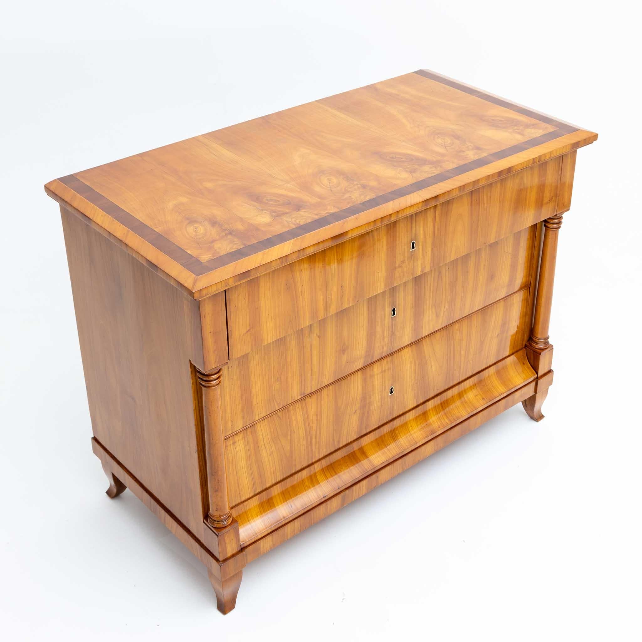 A fine Biedermeier chest of drawers. 
Crafted in cherrywood with columns flanking the
lower two drawers and fruitwood inlay on the top.