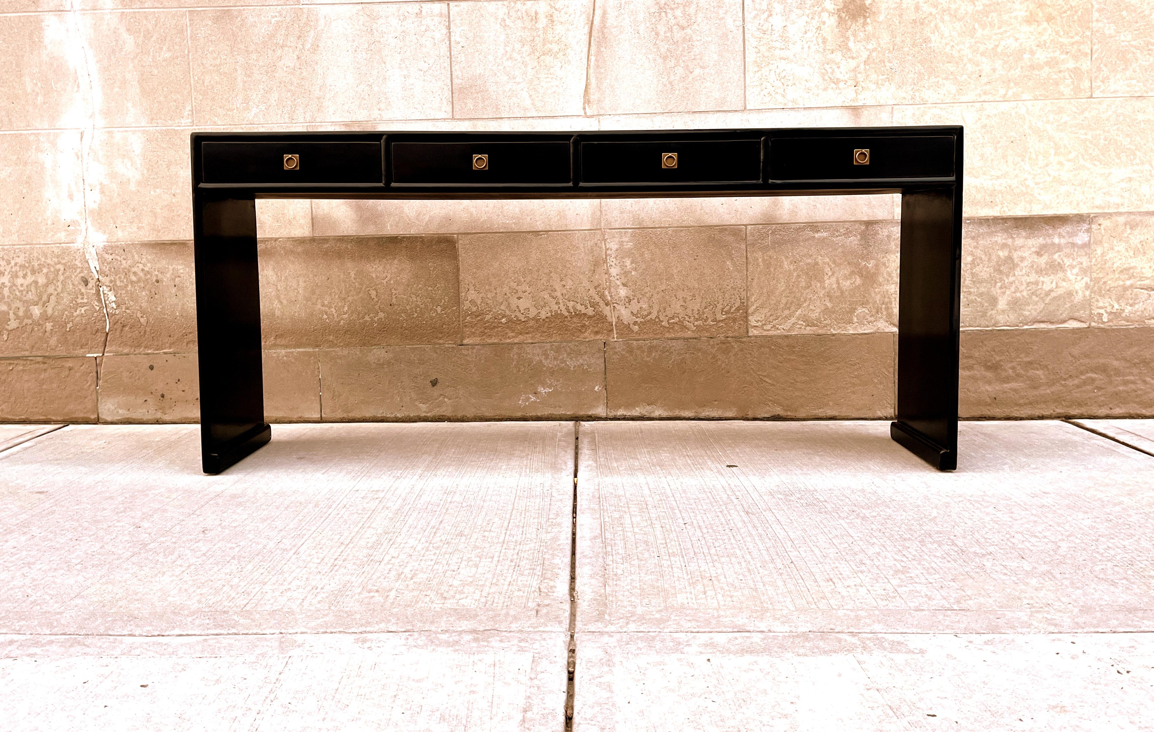 Fine table console en laque noire avec quatre tiroirs, pieds en cascade, ferrure en laiton, forme élégante et simple, belles lignes. Nous proposons des meubles de qualité aux finitions élégantes, qui ont été publiés à plusieurs reprises dans les