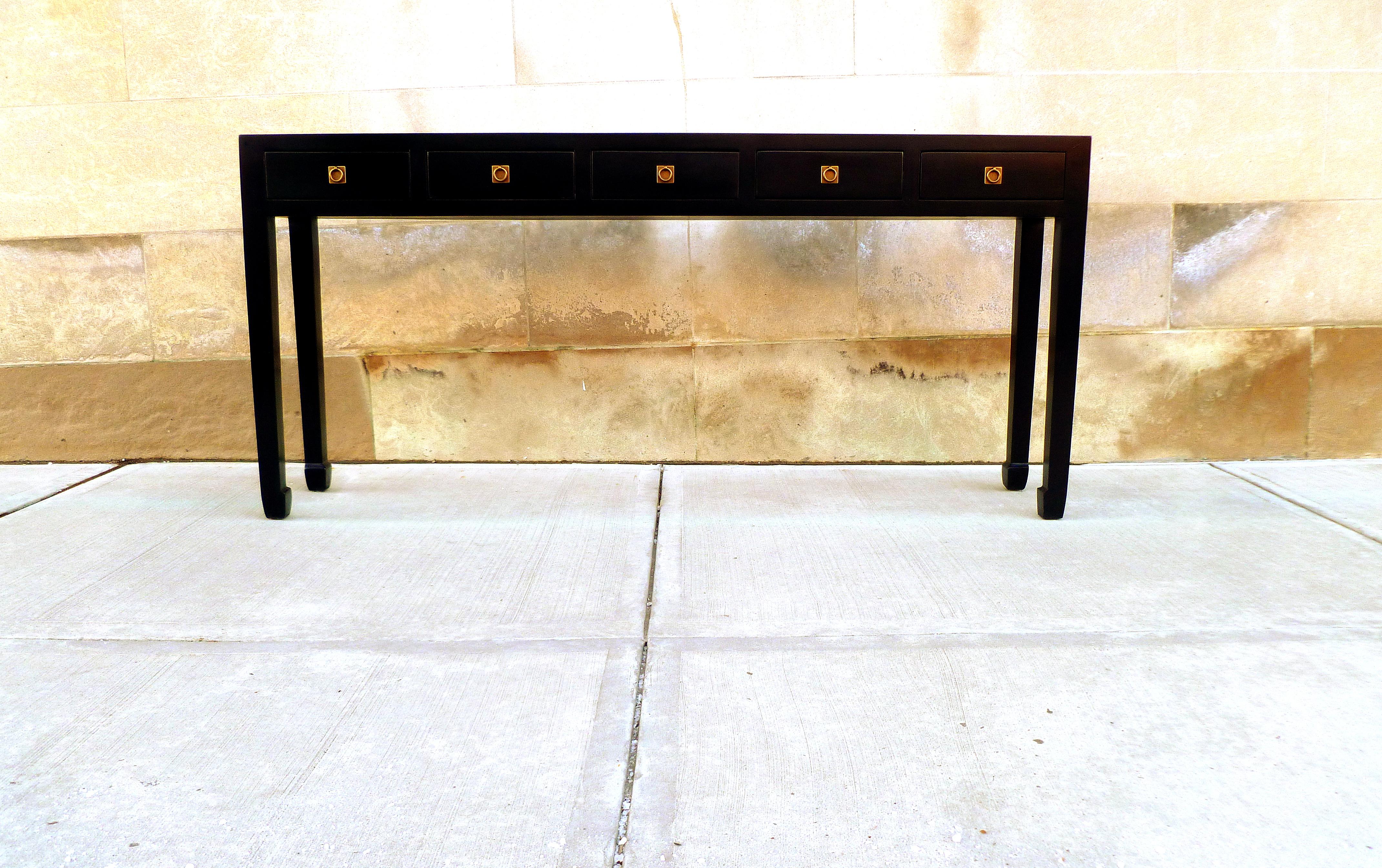 Élégante table console en laque noire avec cinq tiroirs, garniture en laiton. Une forme simple et une belle couleur. Nous proposons des meubles de qualité aux finitions élégantes, qui ont été publiés à plusieurs reprises dans les magazines