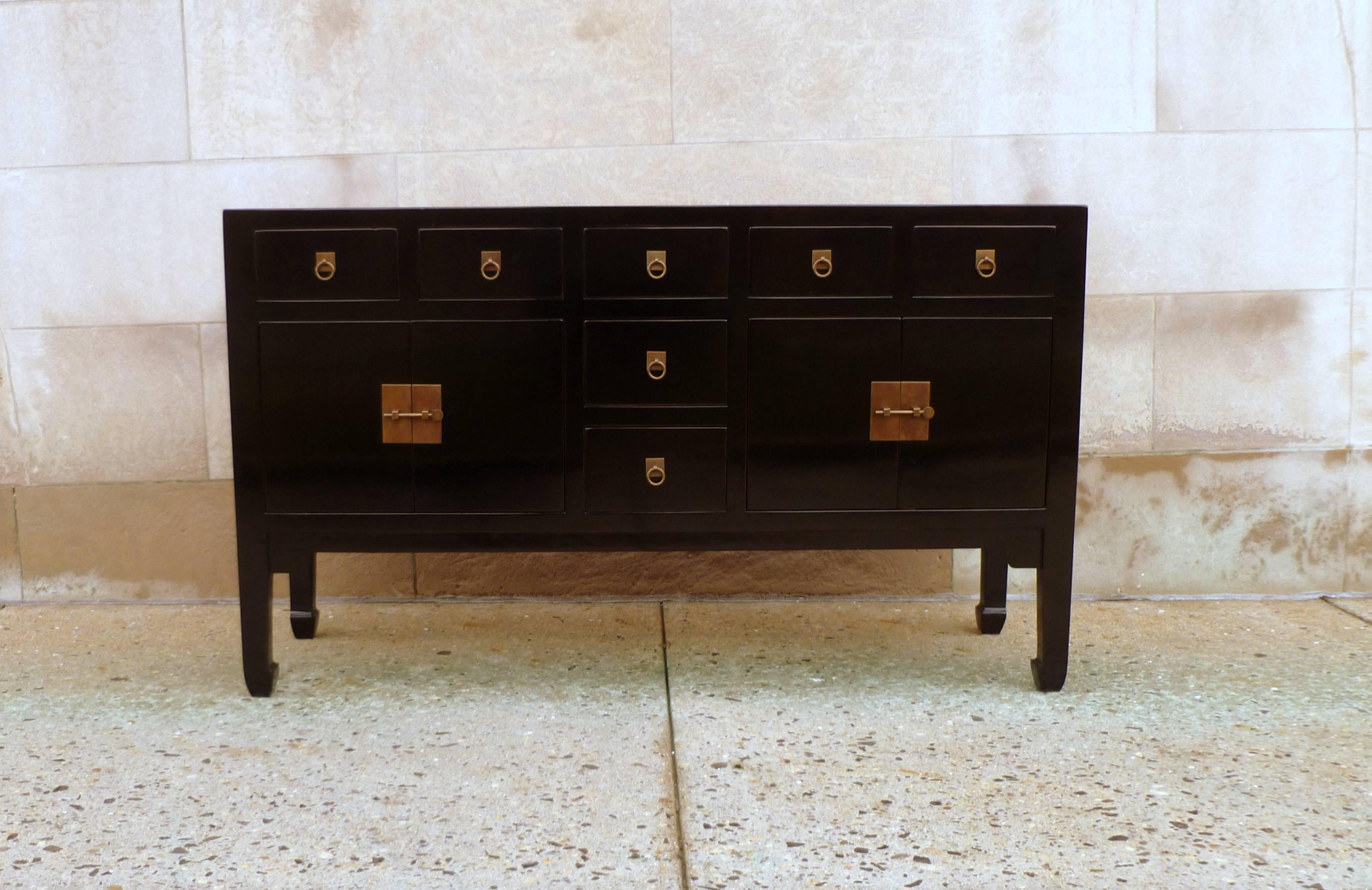 A refined and elegant black lacquer sideboard, framed top supported by square legs and joined by seven drawers and two pairs of doors, brass fitting and ring pulls. We carry fine quality furniture with elegant finished and has been appeared many