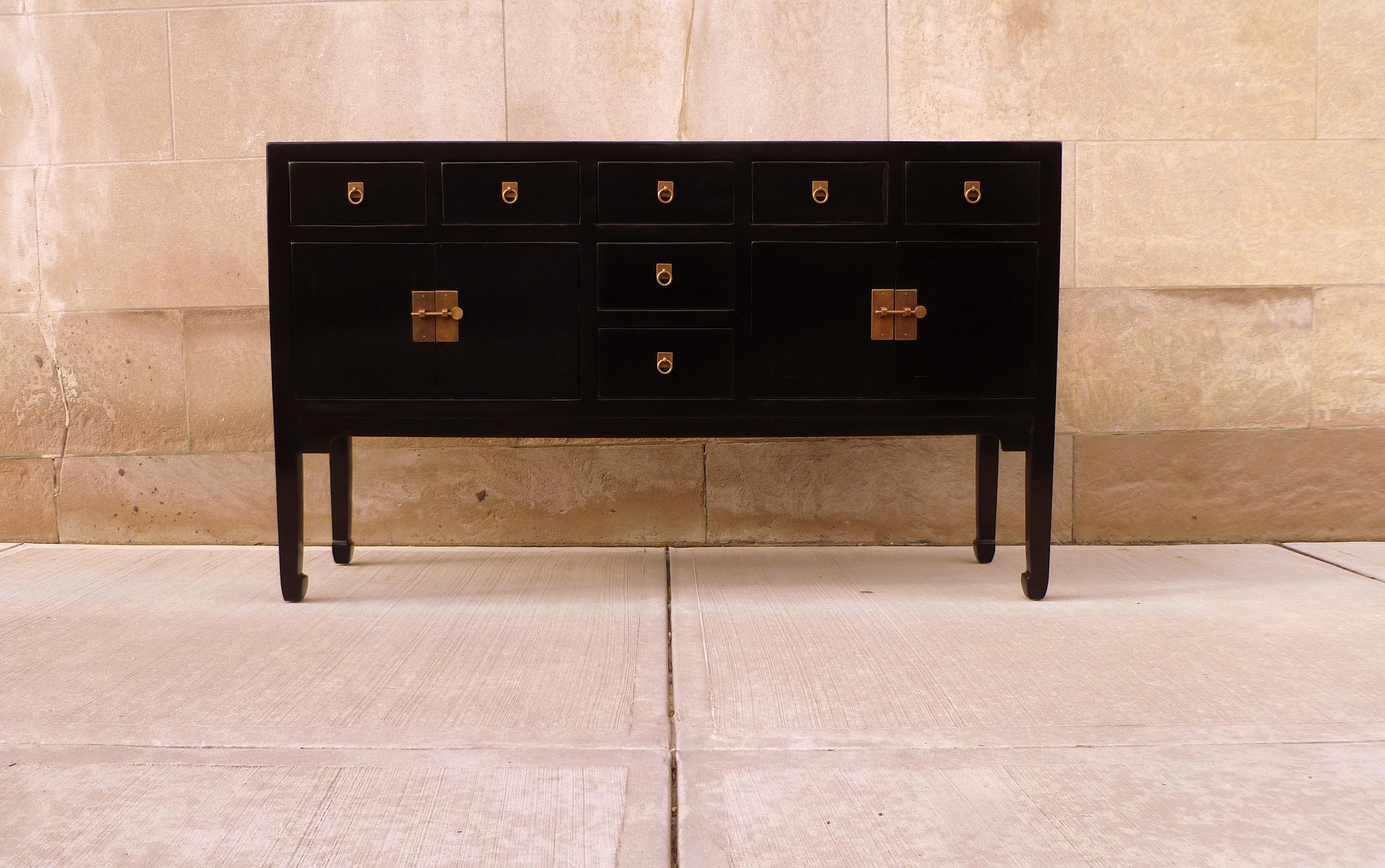 A refined and elegant black lacquer sideboard, framed top supported by square legs and joined by four drawers and two pairs of doors, brass fitting and ring pulls. We carry fine quality furniture with elegant finished and has been appeared many