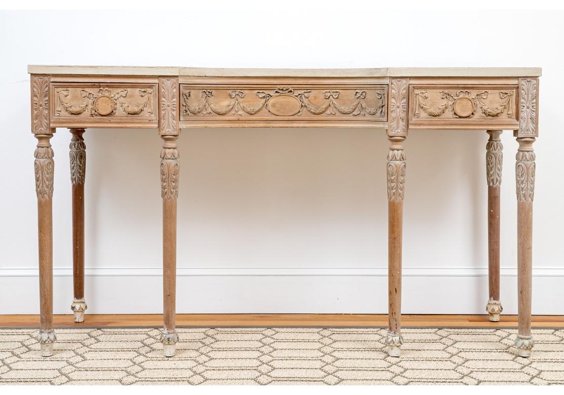 Une table console particulièrement remarquable et décorative avec de délicats motifs français sculptés de guirlandes, de feuillages et de nœuds. Une fois peintes, les sculptures présentent des traces de la peinture crème d'origine. Le toit a été