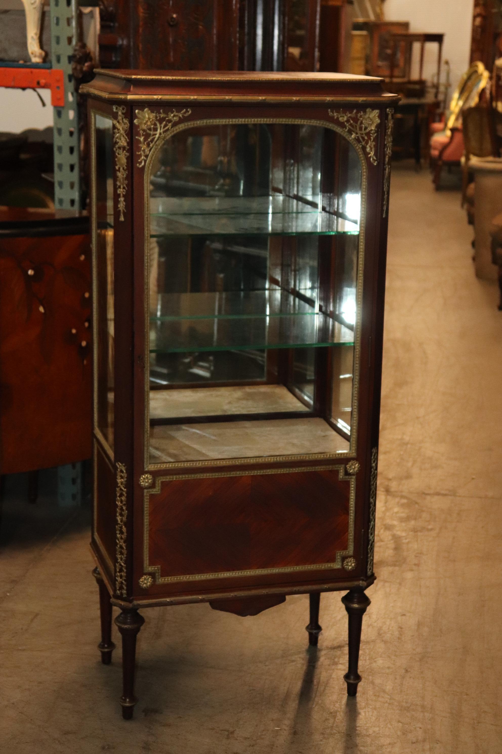 This is a superb quality vitrine in the manner of Francois Linke with gorgeous bronze mounts and glass shelving. The case is made of mahogany and in its original finish and will show fine crazing and some imperfections from age and time. The top has