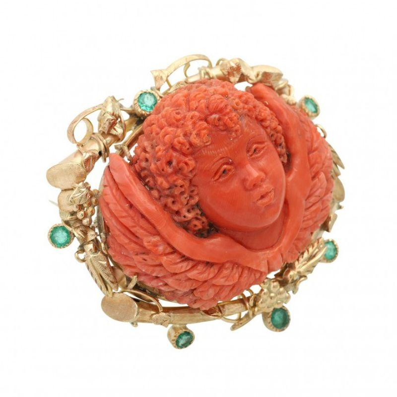 Fine brooch. Especially with 1 coral, elaborately engraved as a putto and emeralds. 9 K. Handmade.