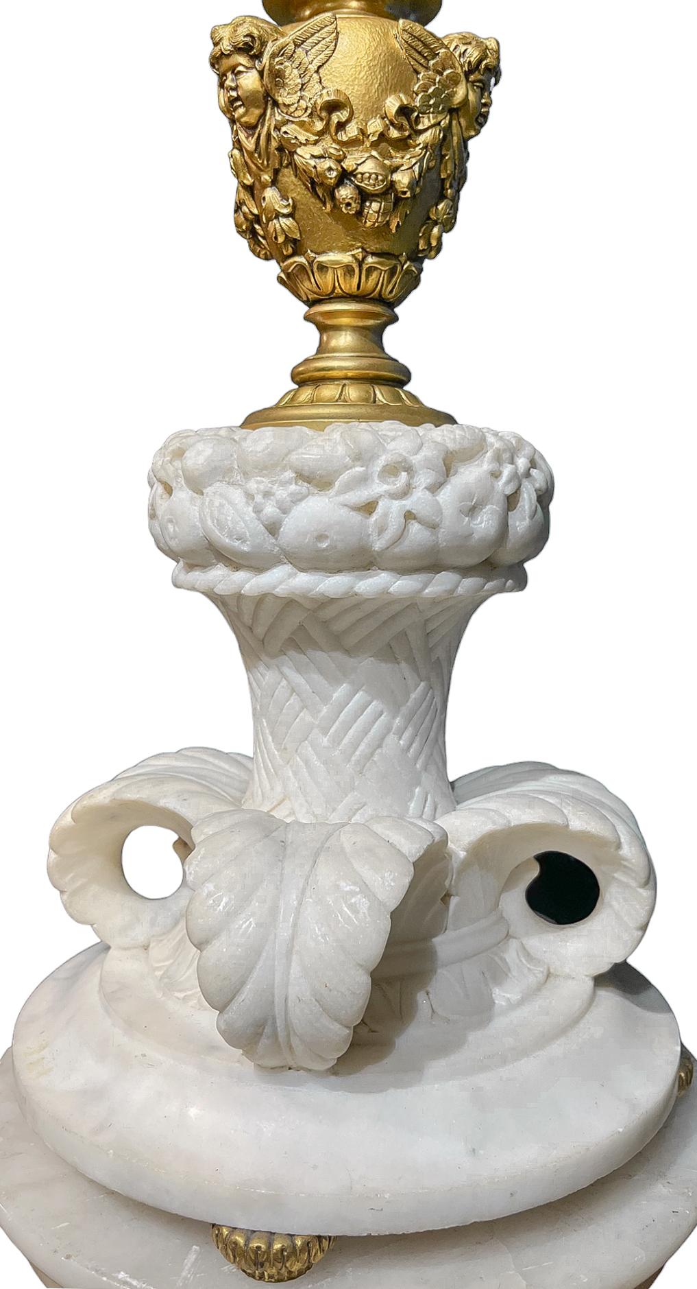  Fine Caldwell Carved Marble & Bronze Lamp with Gilded Cherub heads and a carved marble base raised on bronze bun feet. 

Edward F. Caldwell & Co., of New York City, was one of the premier designers and manufacturers of electric light fixtures and