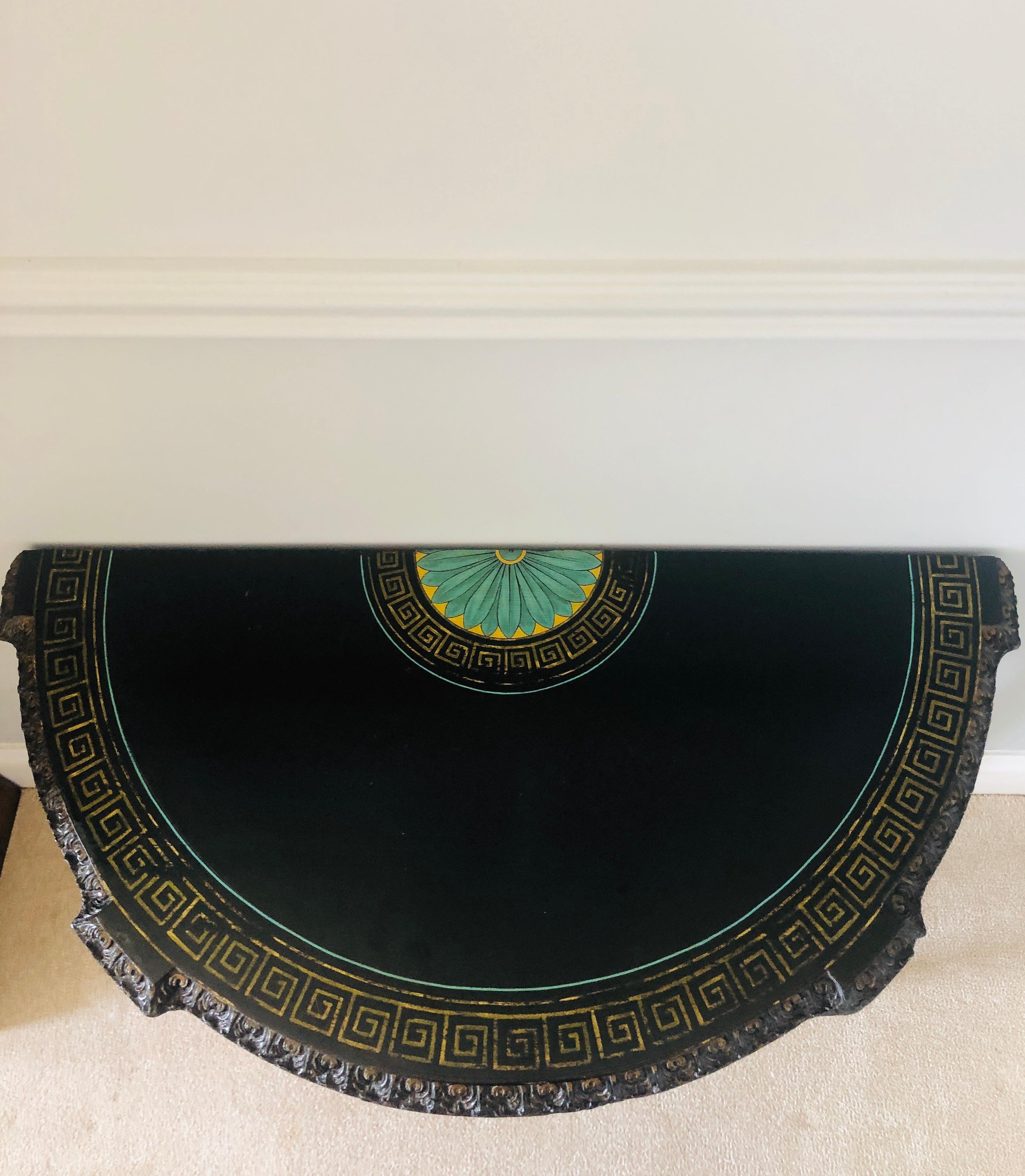 Fine carved French antique demilune shaped ebonized console table having a beautiful painted flower to the rear, delicate gold painted border pattern with a fine carved edge. Intricate carvings to the front and sides with a ribbon bow carved to the
