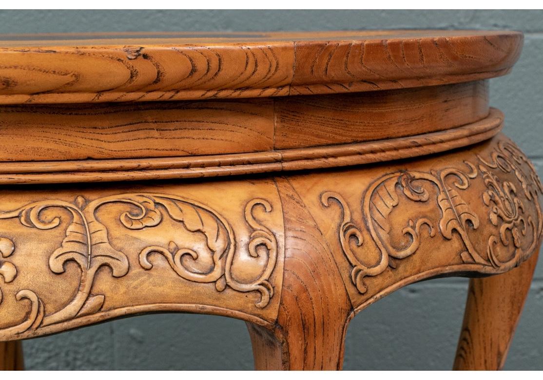 Fine Asian Stand in a tightly grained Elm like hardwood with inset Burl Wood Centerpiece. The table with a dark burled inset center, surrounded with two mixed wood two- tone pieced bands. The wide frieze below carved with foliate bands and palmettes