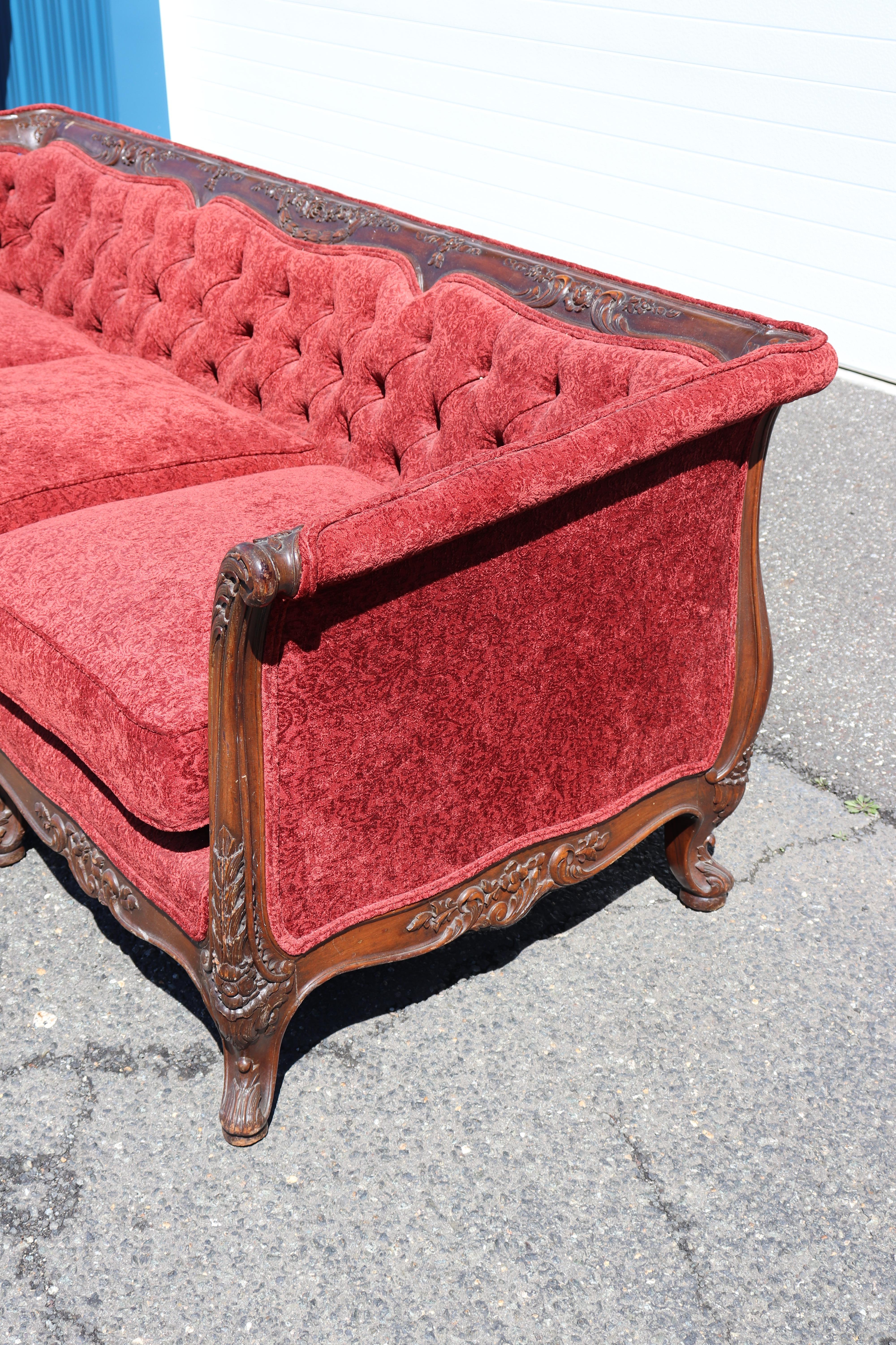 Forma parte de un conjunto de dos piezas con un sillón club que se vende por separado. El sofá está muy bien tallado y en buen estado, con una tapicería roja antigua, y al ser la estructura de brazos iguales resulta muy cómodo sentarse en él. Es