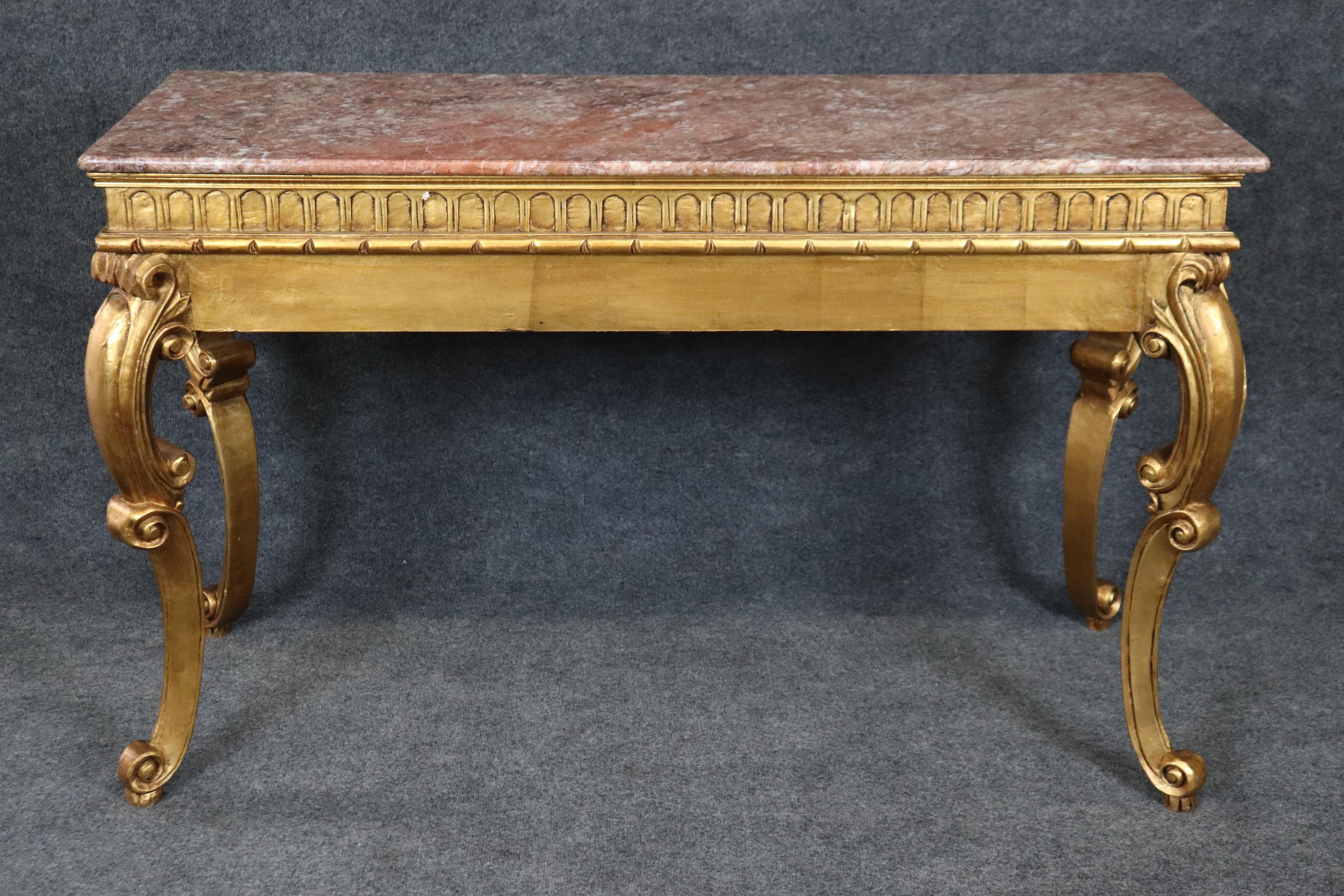 This is a superbly carved, parcel gilt marble top sofa or console table. Because its carved on it's back it can be a true sofa table and stand in the middle of a room. The quality of the carving and the gilding is absolutely superb. The marble top