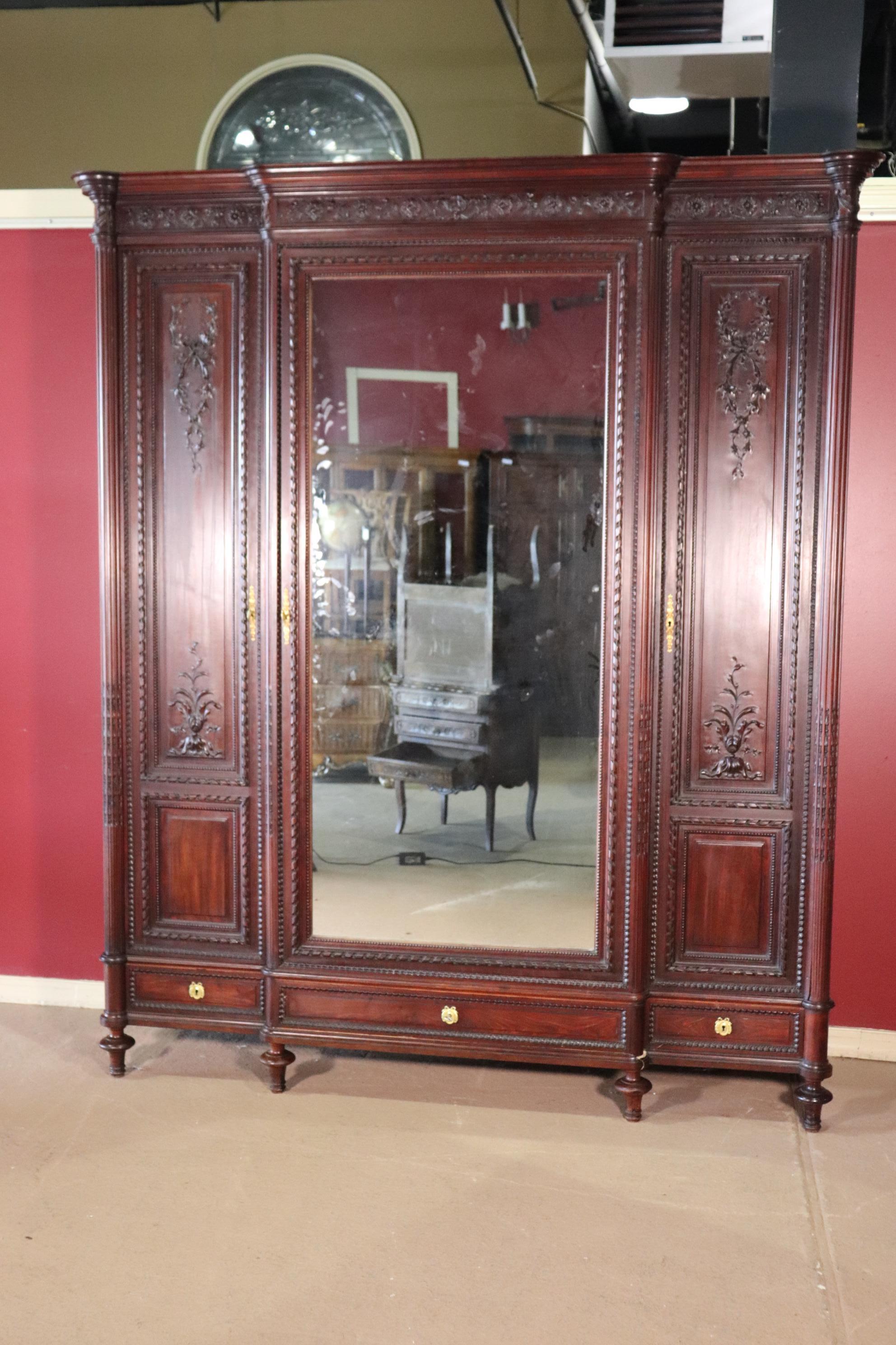 This is a beautiful carved mahogany armoire. The armoire features its original finish and has gold dore bronze hardware. The mirror is clear too. The armoire measures 95 tall x 85 wide x 20 deep.