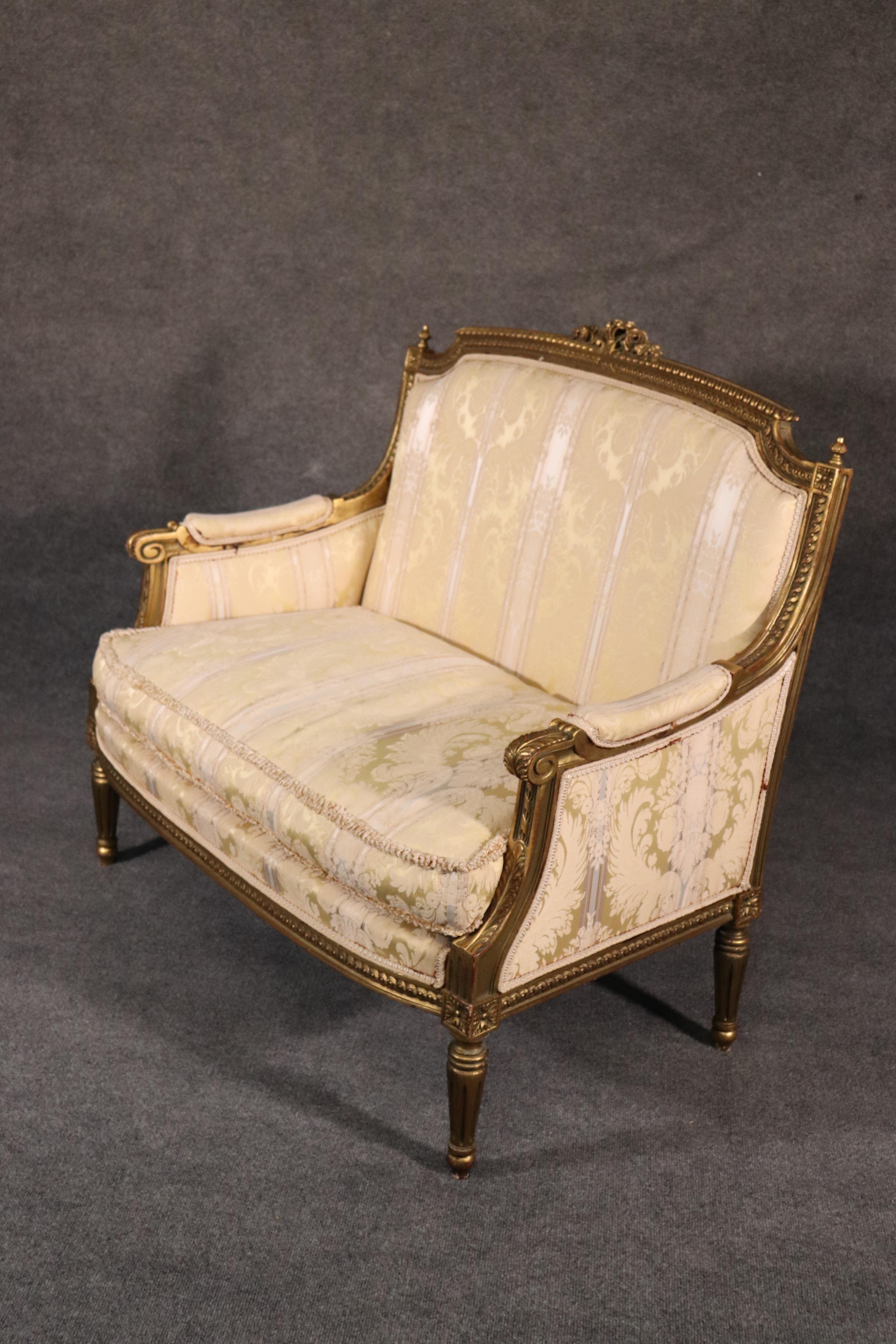 This is a gorgeous settee designed in the manner of Maison Jansen. The settee is 1930s and in excellent condition. The fabric is also rather good though as it's used its not perfect. The gilding is just wonderful and beautiful. The settee measures