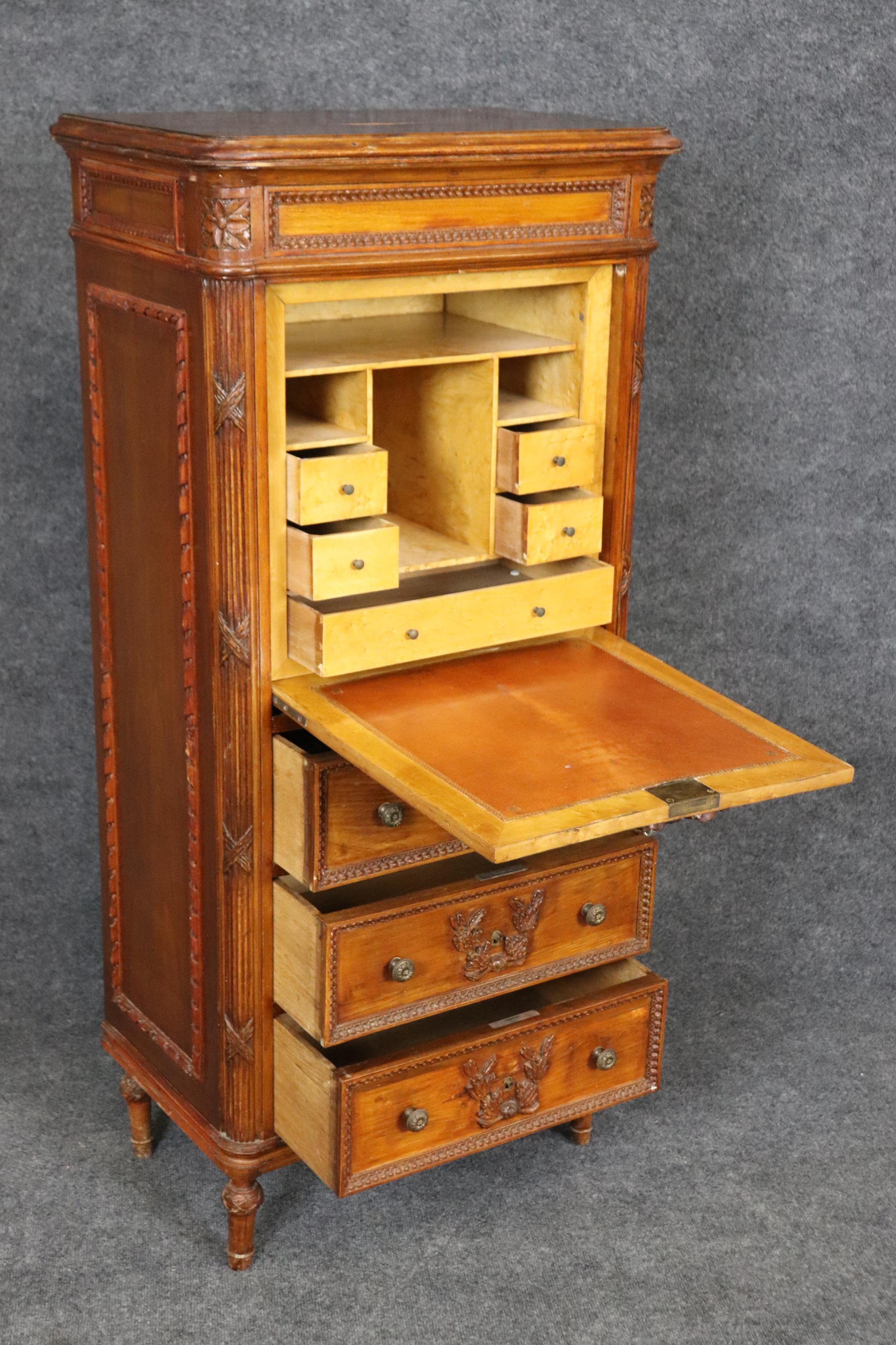 This is a superb carved walnut secretary abatant that's perfect for narrow hallways or shallow areas in a bedroom. The desk is repleat with a tulipwood interior and leather writing surface. The back leg on the left side will be repaired and reset
