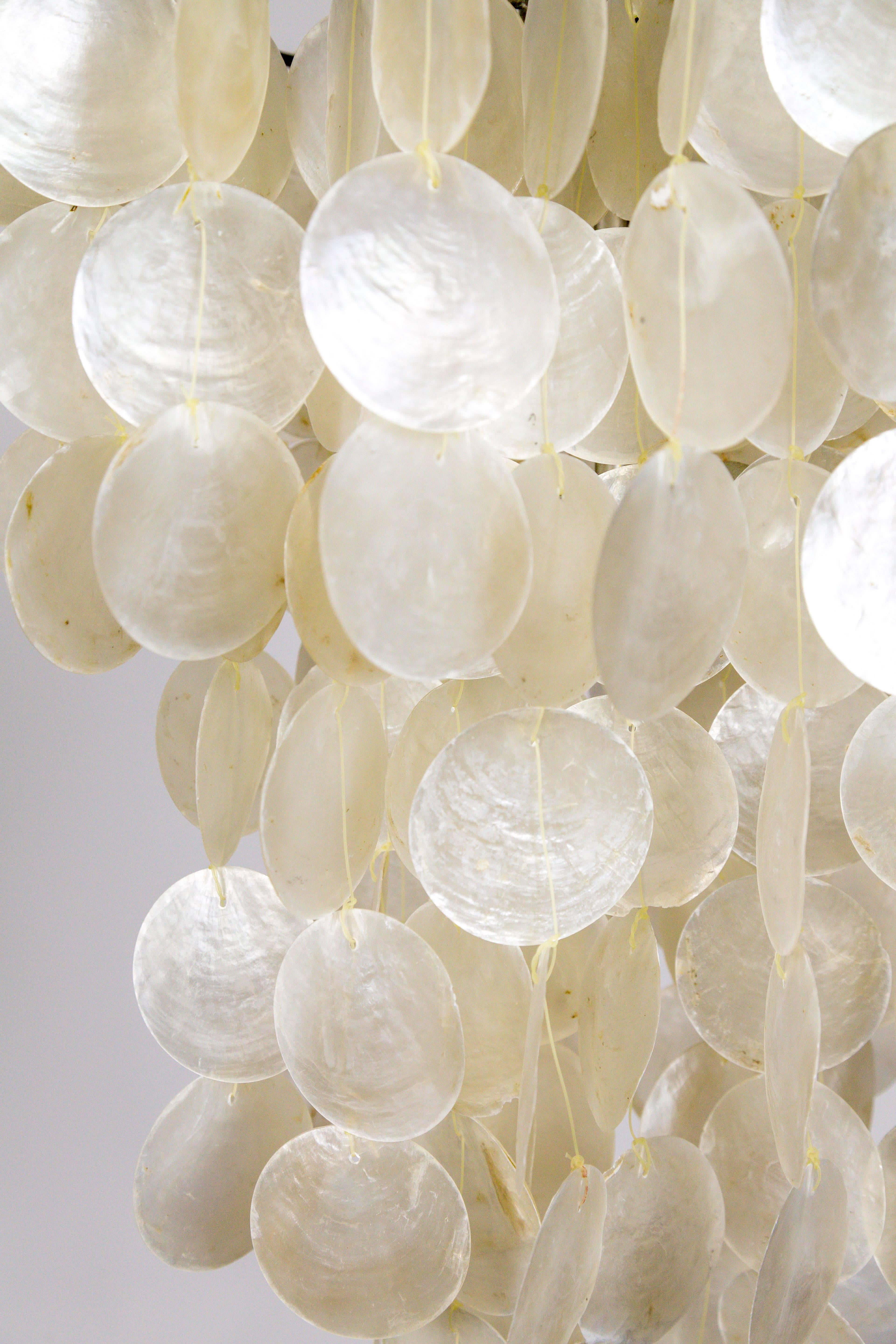This distinctly fine capiz shell pendant light casts a beautiful glow. It's delicate, pearlescent appearance looks beautiful reflecting in the changing light of the day. It's solid, antique silver finished armature holds a two-socket medium base