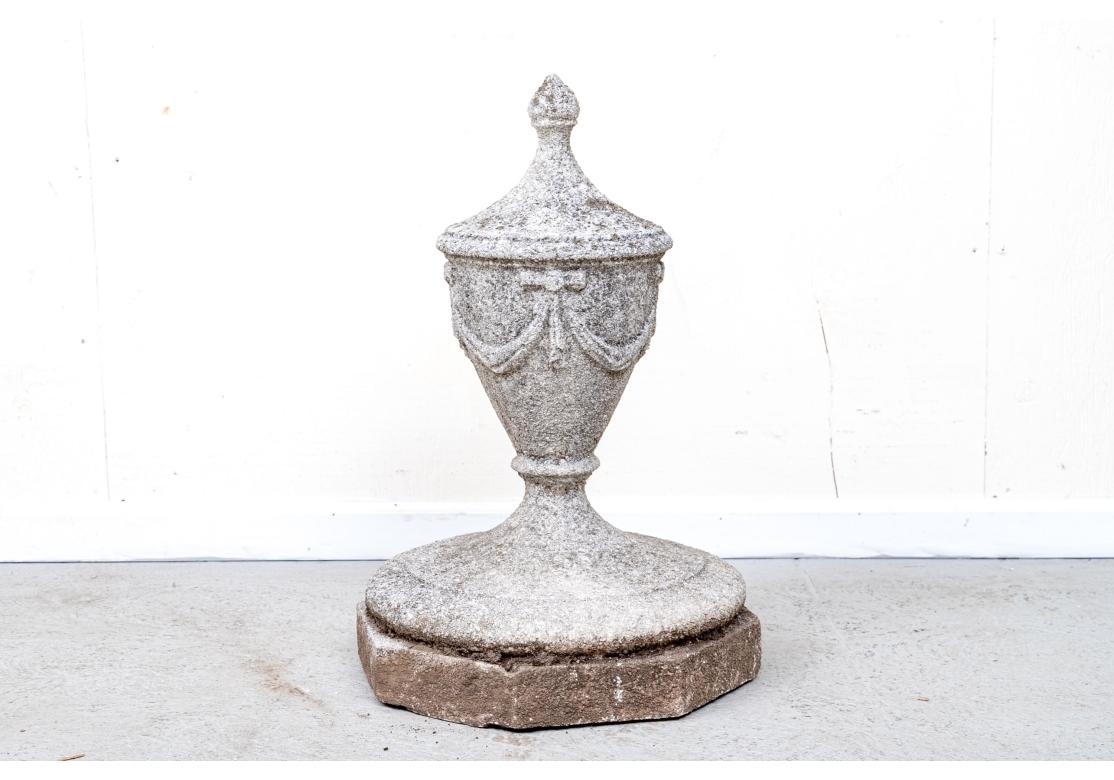 Una gran urna de jardín de piedra maciza de fundición bien elaborada sobre una plataforma octogonal. La urna con guirnaldas decorativas y un bonito acabado texturizado y desgastado. 

Dimensiones: 27