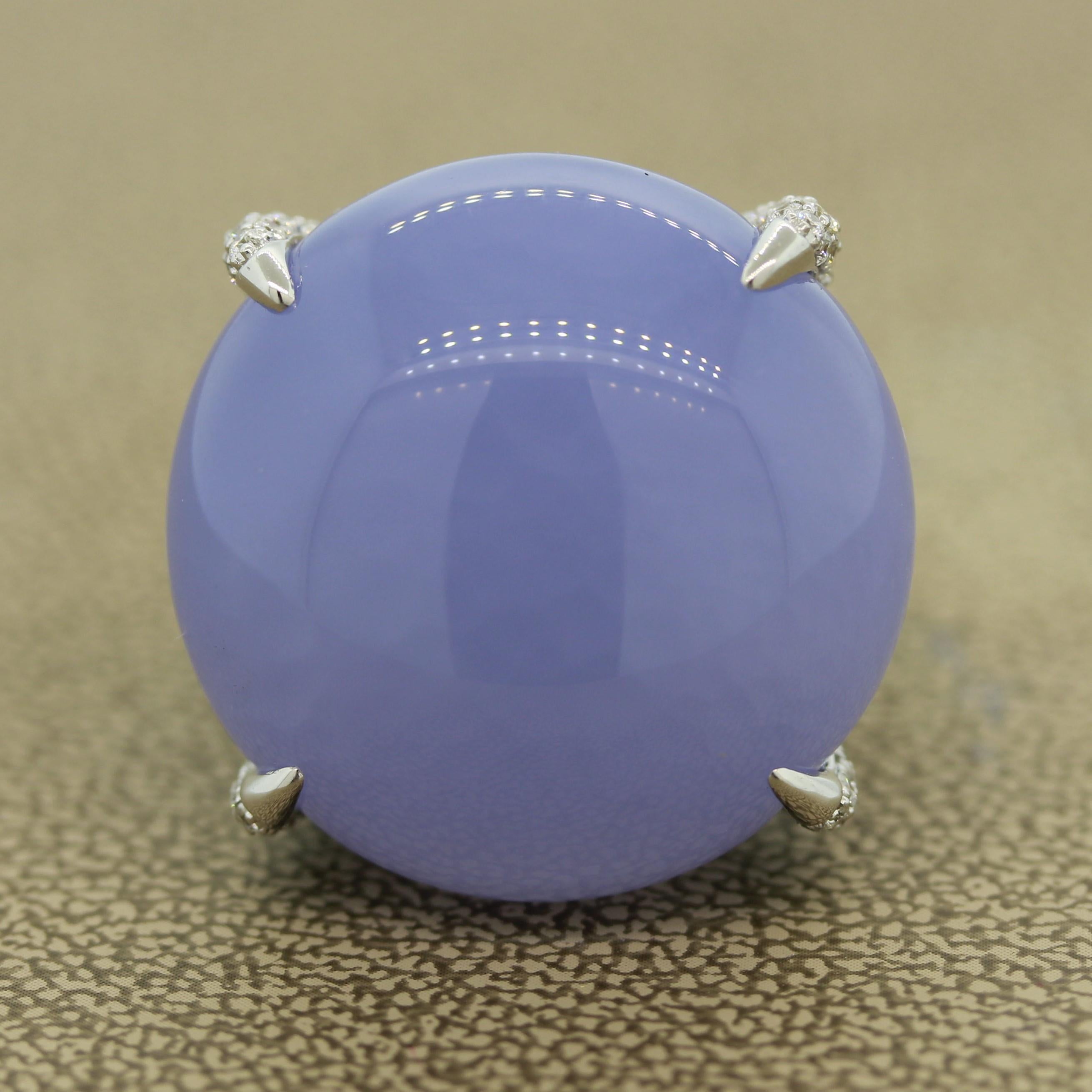 A luscious extra fine quality violetish-blue chalcedony is proudly set atop this ring (52.86 carats). The 4 claw martini prongs are set with 2.72 carats of blue sapphires that graduate in color to match the round brilliant cut diamonds weighing 0.50