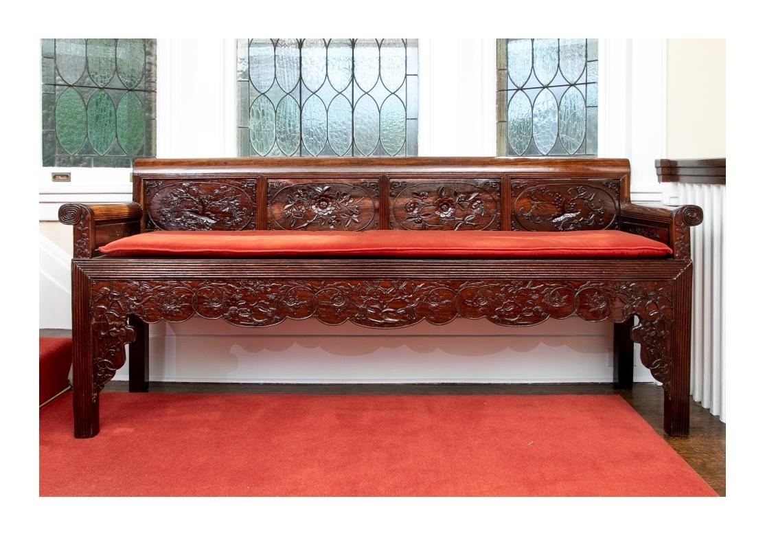 Panca in legno scuro lucidato a specchio, con ringhiera e braccioli a volute. Quattro pannelli posteriori intagliati e decorati con frutta e viti floreali. I lati interni presentano motivi di foglie intagliate in modo complementare. Con una