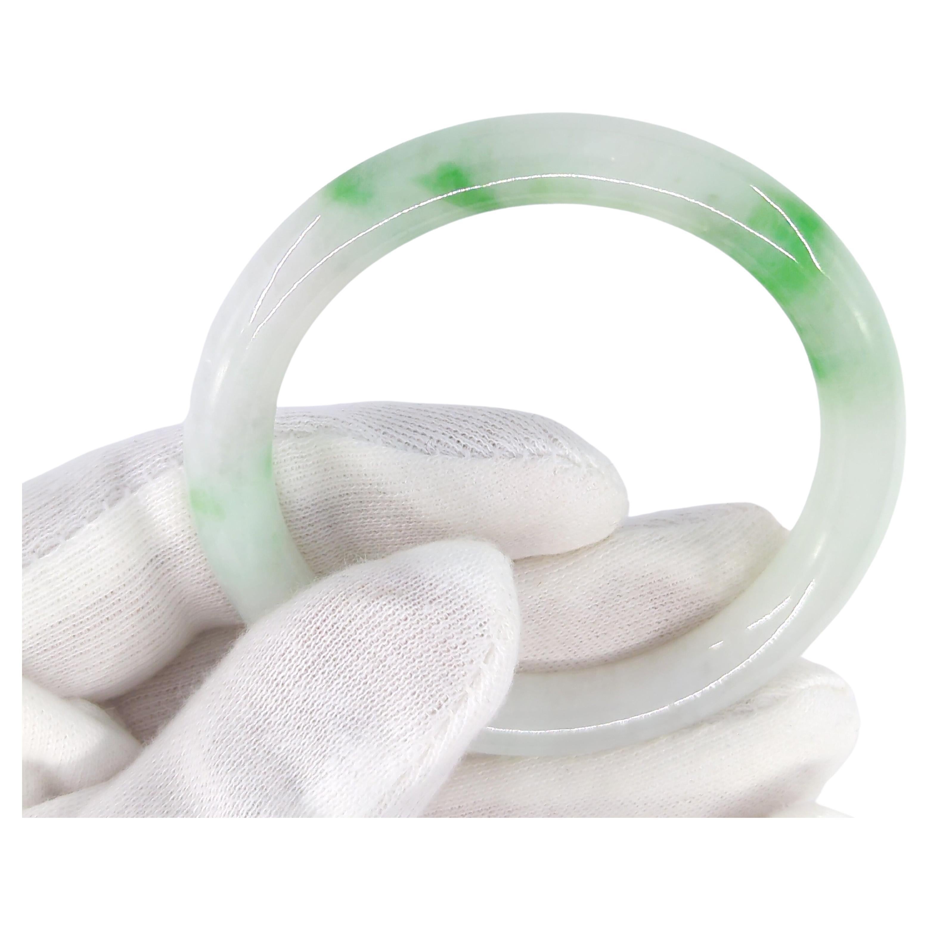 Antique Chinese carved natural jadeite bangle, on fine and uniform white ground with two prominent spots of apple green inclusions, and several smaller ones. This bangle exhibits true understated elegance and makes a  statement on your wrist

ID: