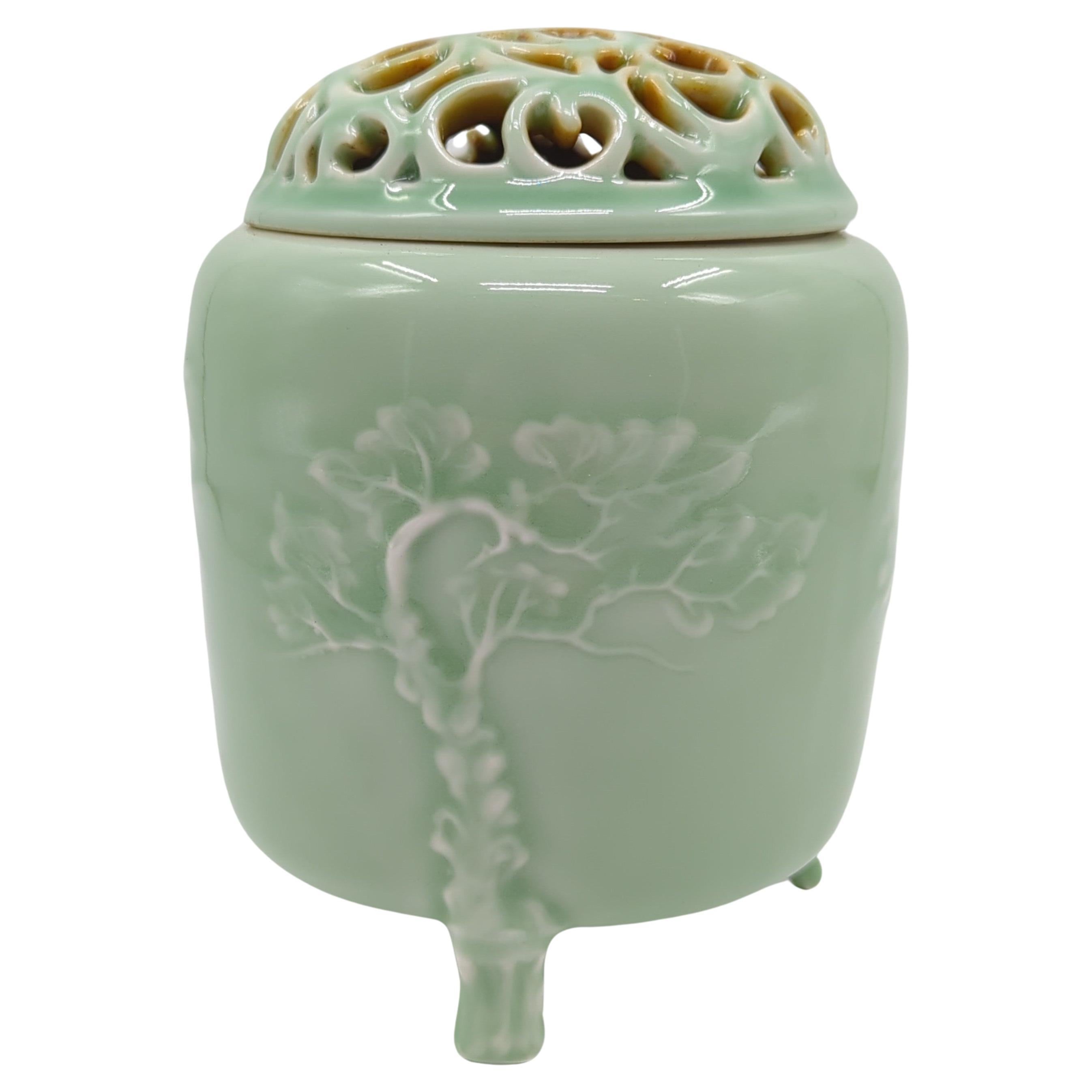 Cet encensoir couvert exceptionnel est un témoignage de l'art de la céramique chinoise, exécuté avec une habileté et un souci du détail remarquables. La pièce est enveloppée d'une glaçure céladon raffinée, une couleur révérée pour sa subtilité