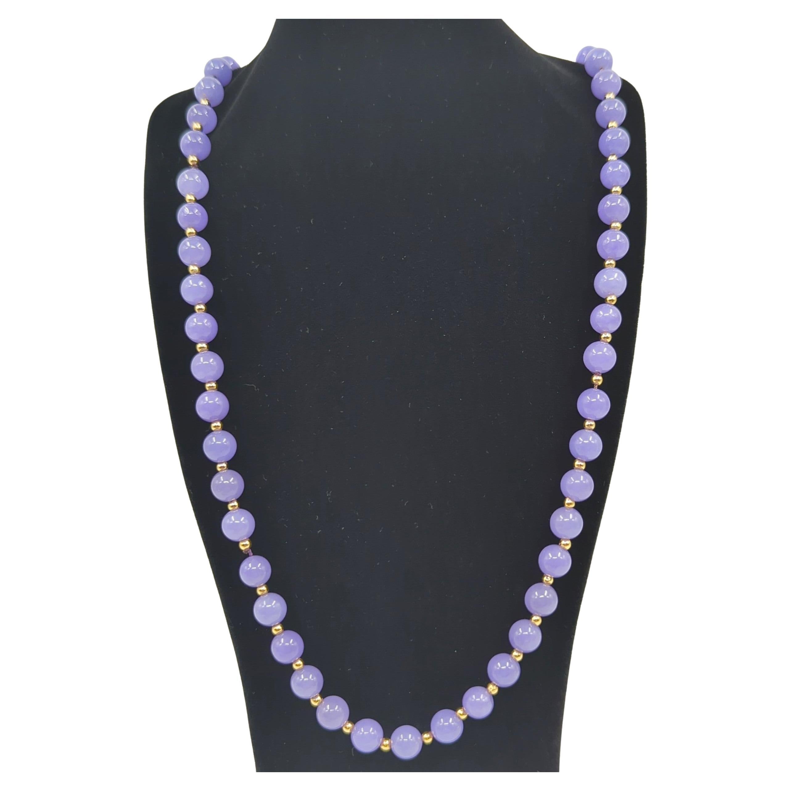 This vintage Chinese natural lavender jadeite beaded necklace is a striking piece of jewelry that showcases the exquisite beauty and rarity of lavender jadeite. The jadeite beads exhibit an intense bluish-purple lavender color, a hue that is both
