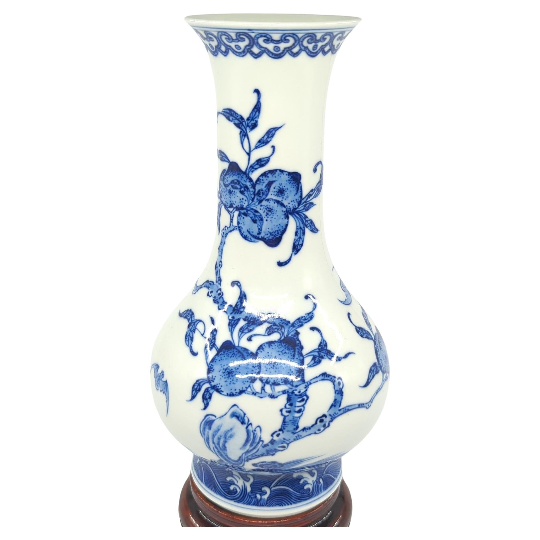 This finely painted Chinese porcelain vase is a masterful representation of Qing style, executed in underglaze blue and white. The vase takes on a classic bottle form, characterized by an outward flaring mouth rim that adds a touch of elegance to