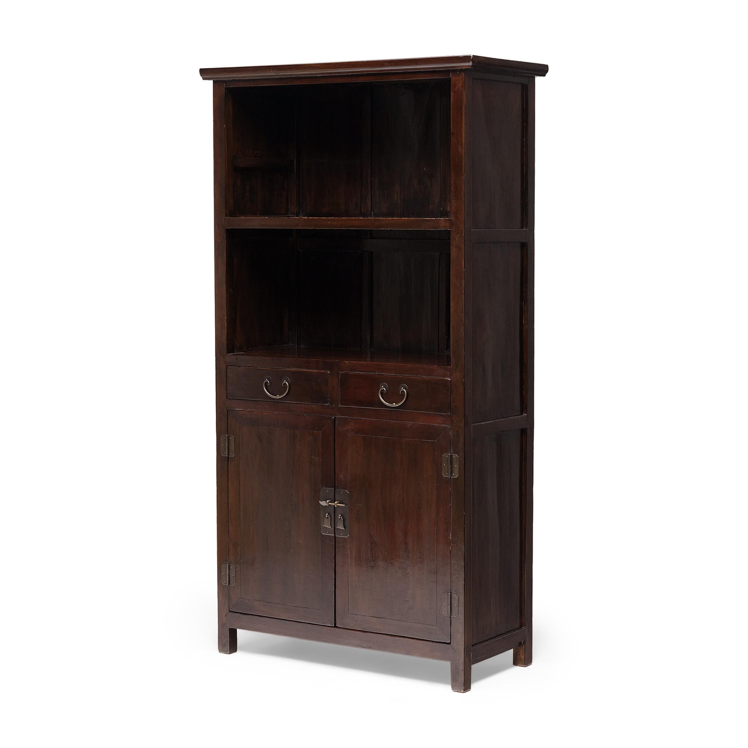 Cette élégante vitrine de la fin du XIXe siècle illustre la perfection des lignes et des proportions qui rend le mobilier chinois classique si intemporel. Le meuble haut est d'une simplicité raffinée, dépourvu de sculptures en surface ou de