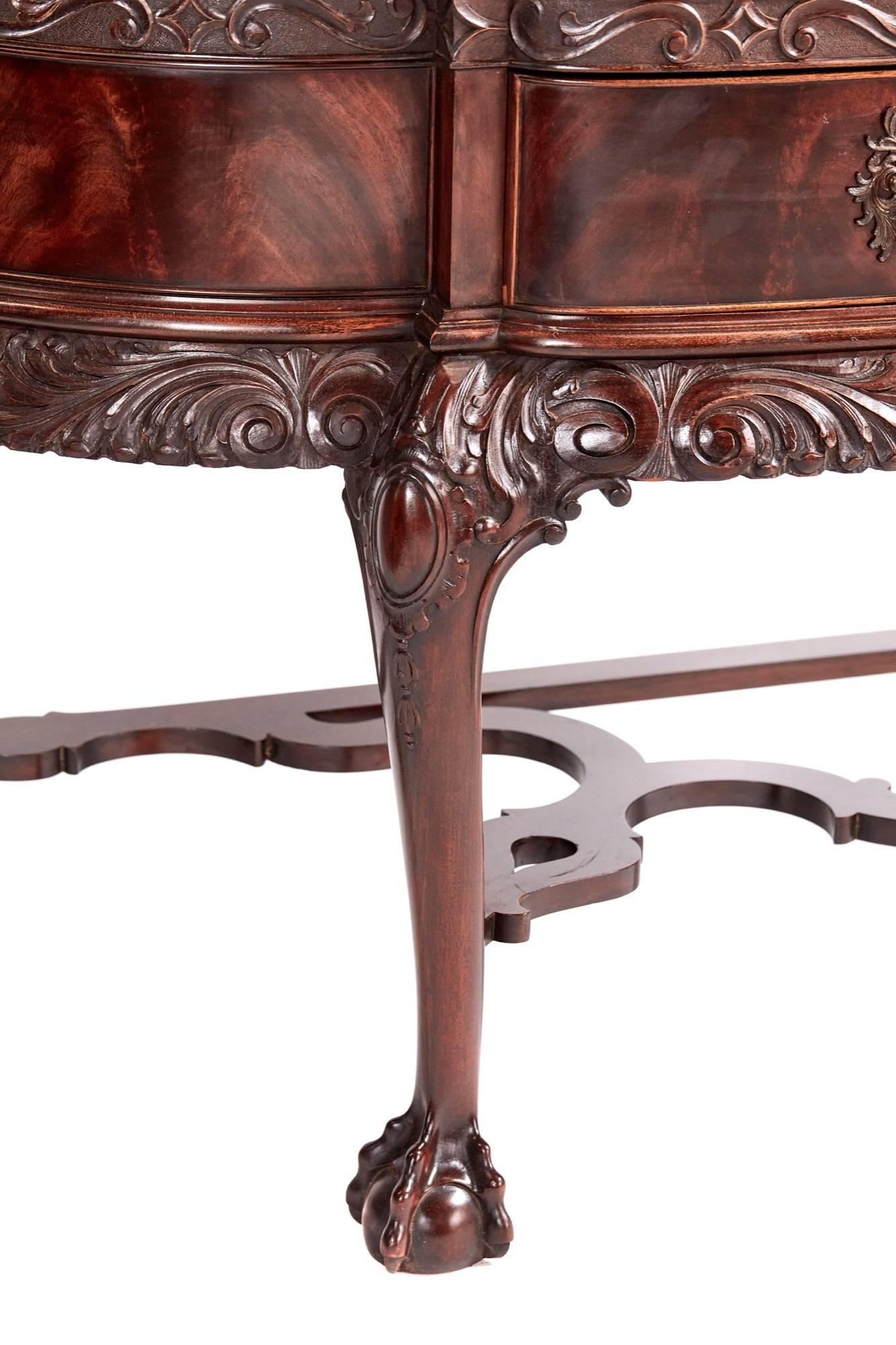 Fine Chippendale revival carved mahogany breakfront display cabinet, with a fret carved pediment above an acanthus carved frieze and glazed doors decorated with acanthus scrolls and flowerbell mouldings, with conforming glazed wings enclosing two