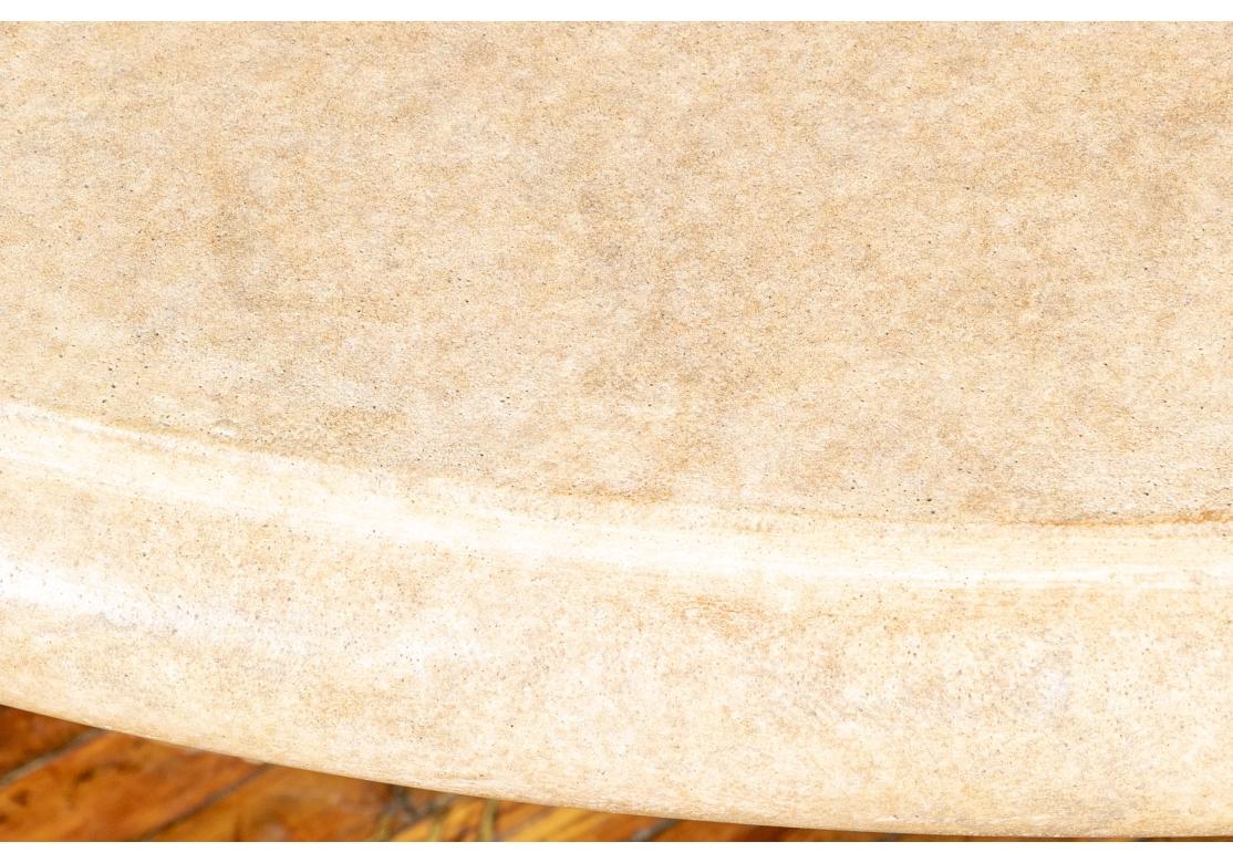 Un grande e straordinario tavolo in finta pietra dalle forme classiche. Il piano rotondo poggia su una base a treppiede con motivo a foglie d'acanto e sia la base che il piano sono in una piacevole finitura verniciata a chiazze chiare. Con grande
