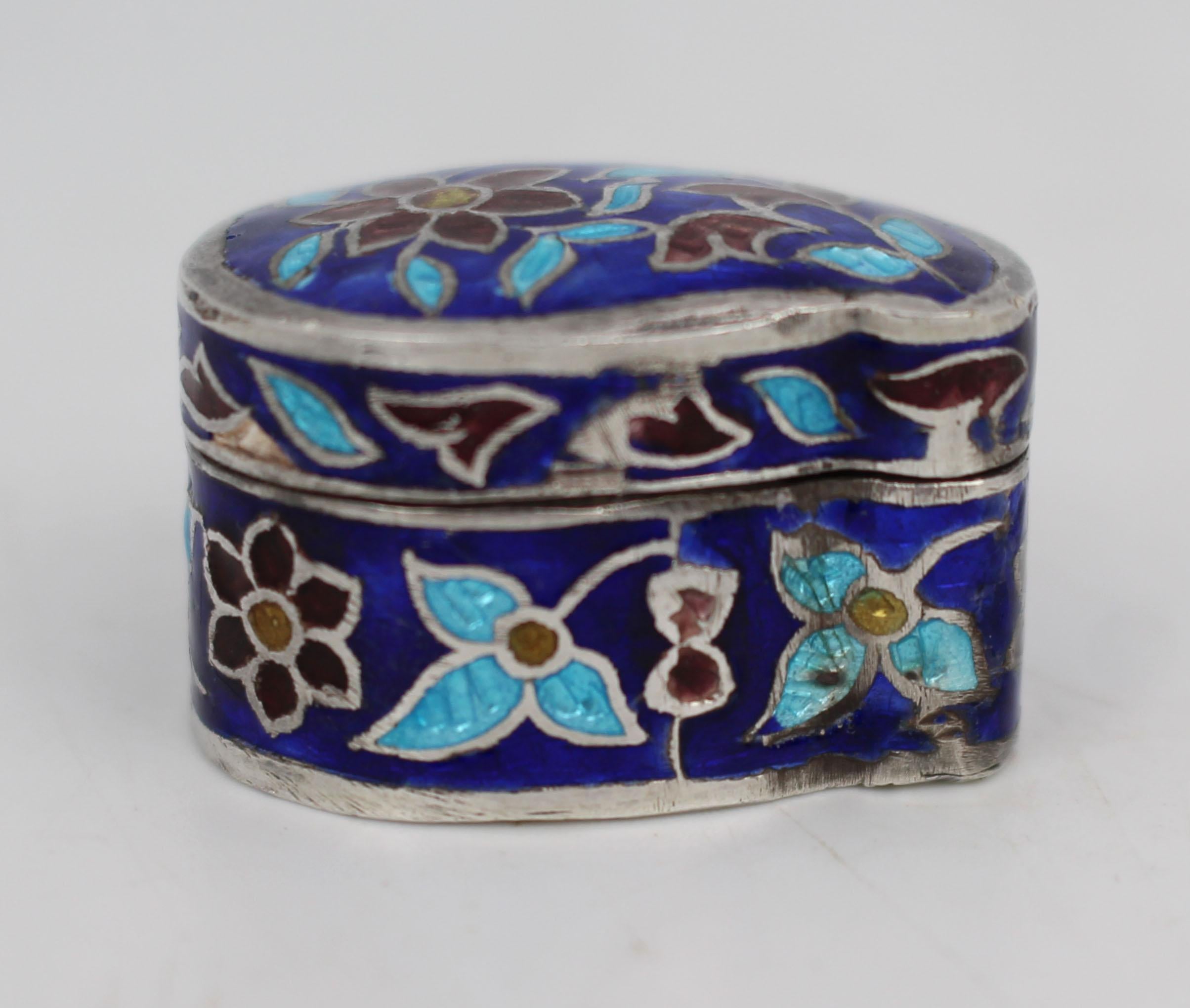 Fine Cloisonné Enamel Sterling Silver Pill Box, India, circa 1970

A finely crafted kidney-shaped sterling silver pill box, delicately enamelled throughout in vibrant shades of cobalt blue, turquoise, burgundy and soft yellow. The body is decorated