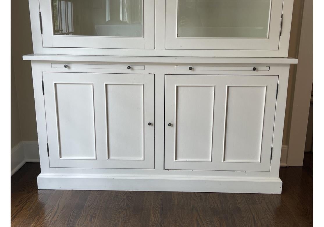 A very made Cabinet with simple elegant lines, X decorated glass panel doors, four adjustable top shelves and one fixed shelf below. There are two pull out returns for help in sorting and all of the doors with contrasting Pewter tone pulls. The