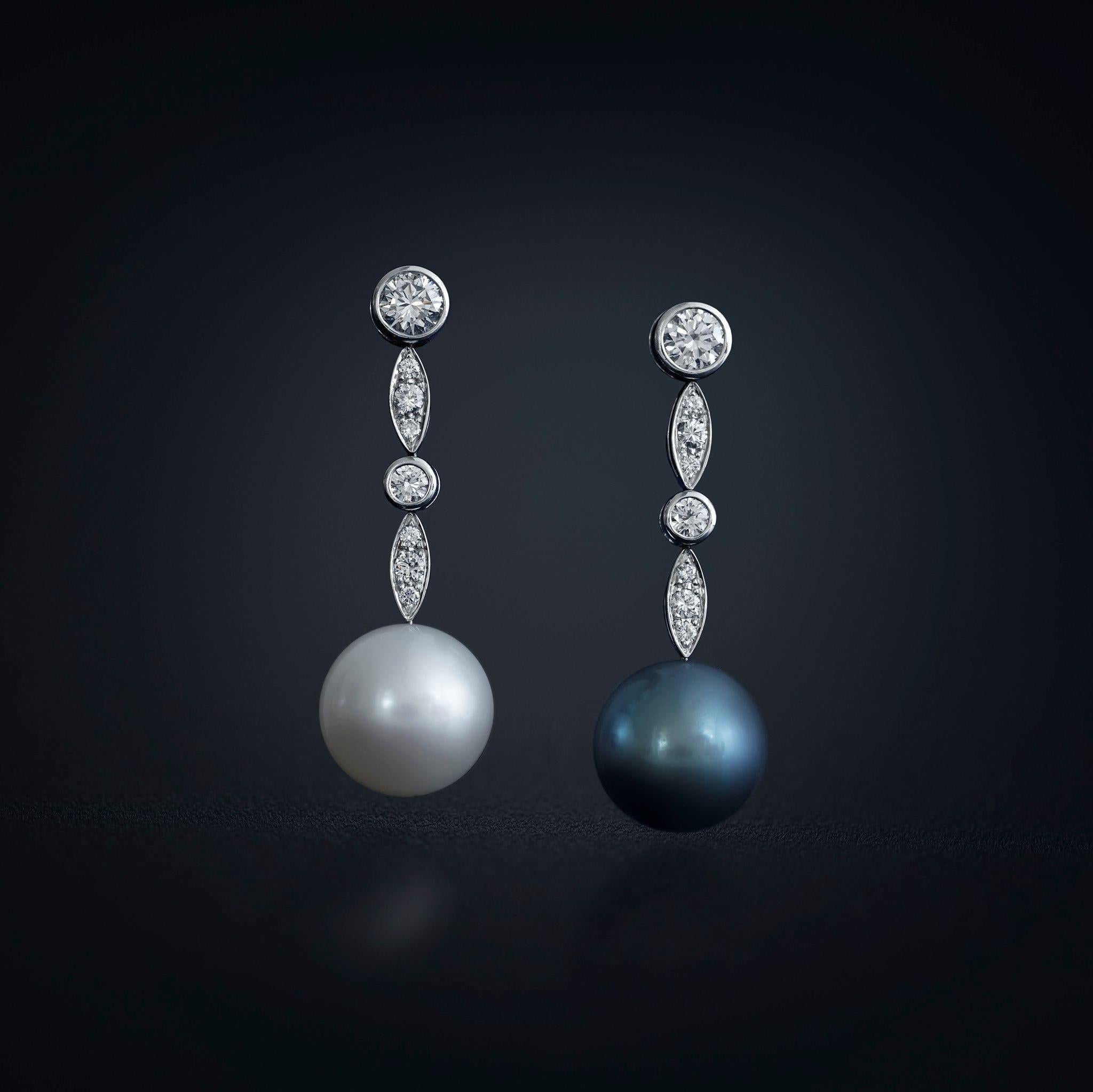 Impressive pair of a white South Sea and a dark grey Tahitian Cultured Pearl. With spectacular 15mm in size, perfectly round, a very high luster and a clean surface this pair can be considered as rare. The earrings are in four point's movable, which