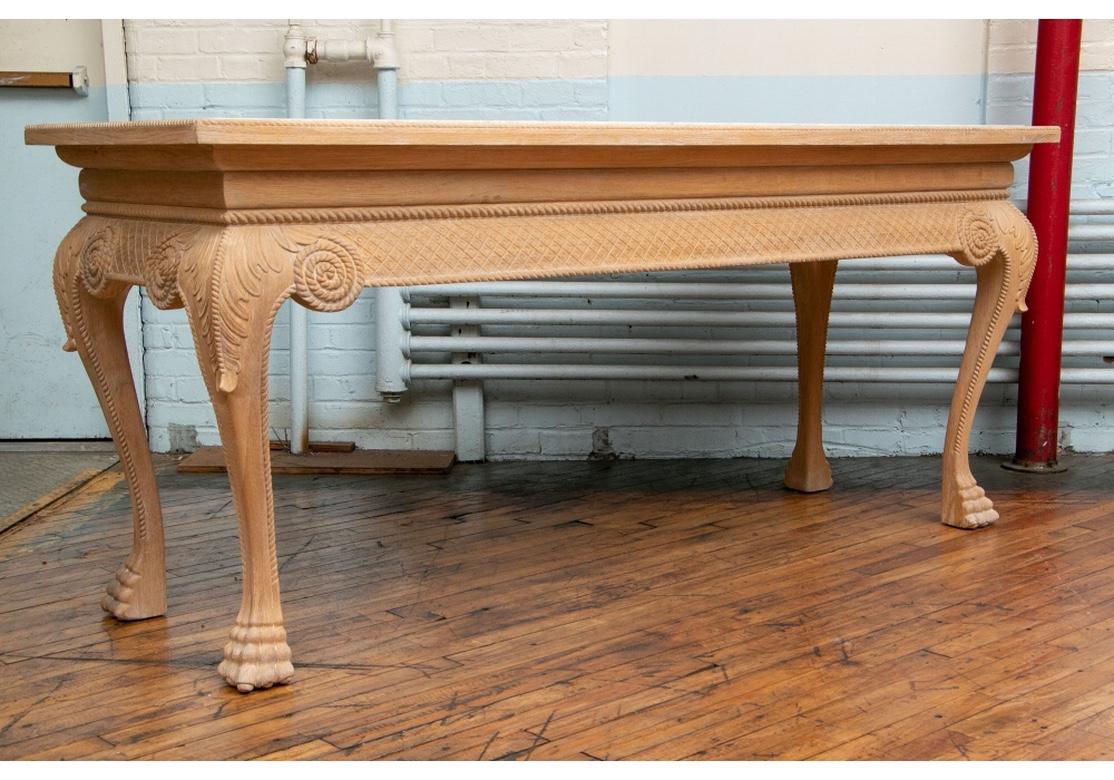 A large and very well carved console with good size and robust form. Having a white marble inset top raised on curved legs having water leaf capped knees terminating on paw feet. The whole decorated with carved rope turned moldings. The oak with