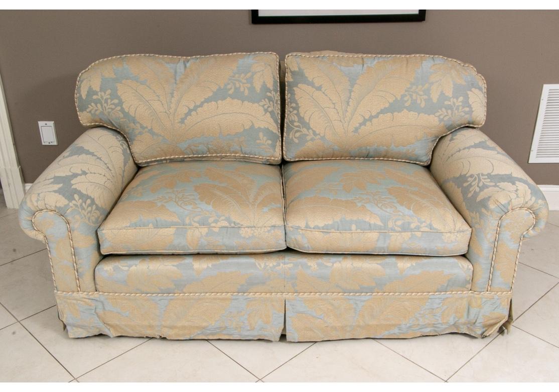 Very comfortable and in very good condition. With a fabric treatment in a sophisticated woven leaf pattern in wheat tones having a pale celadon blue background, and the frame and back cushions have a complimenting twisted roping trim in pale tans