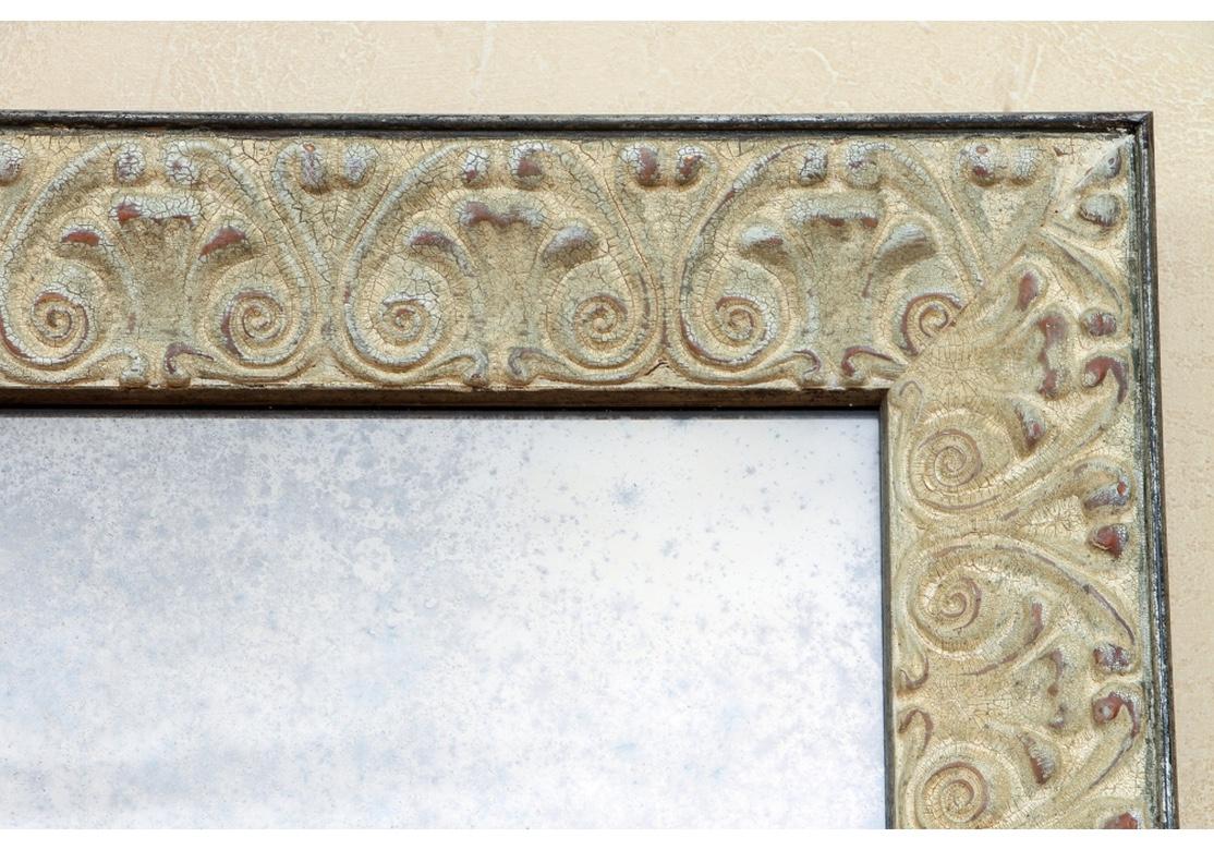 A very large custom mirror originally configured for horizontal use which serves very well if used vertically. The surround decorated with a band of palmettes in relief in ecru paint with intentional distressing, craklure, and wear. The mirror glass