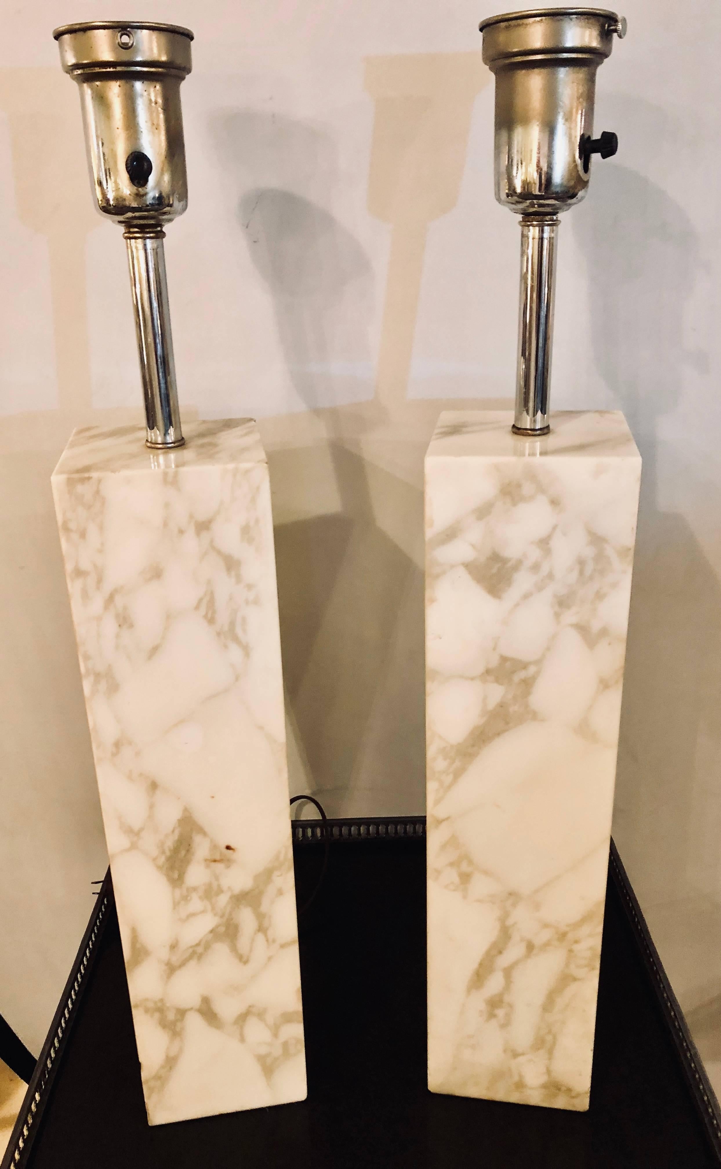 A fine custom pair of Mid-Century Modern Robsjohn-Gibbings white and gray veined marble column form table lamps. The square tall form with a single bulb socket.