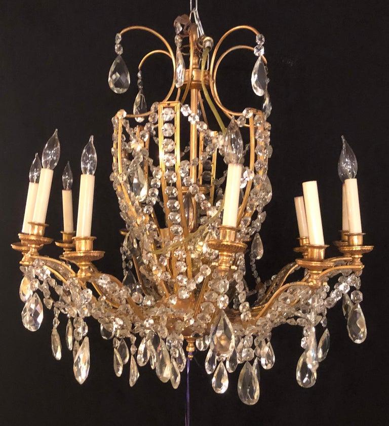 Fine cut crystal and gilt bronze neoclassical eighteen-light chandelier. This finely cast chandelier has six interior lights and twelve lighted outer candelabra lights. Certain to light up the largest of spaces this neoclassical chandelier is