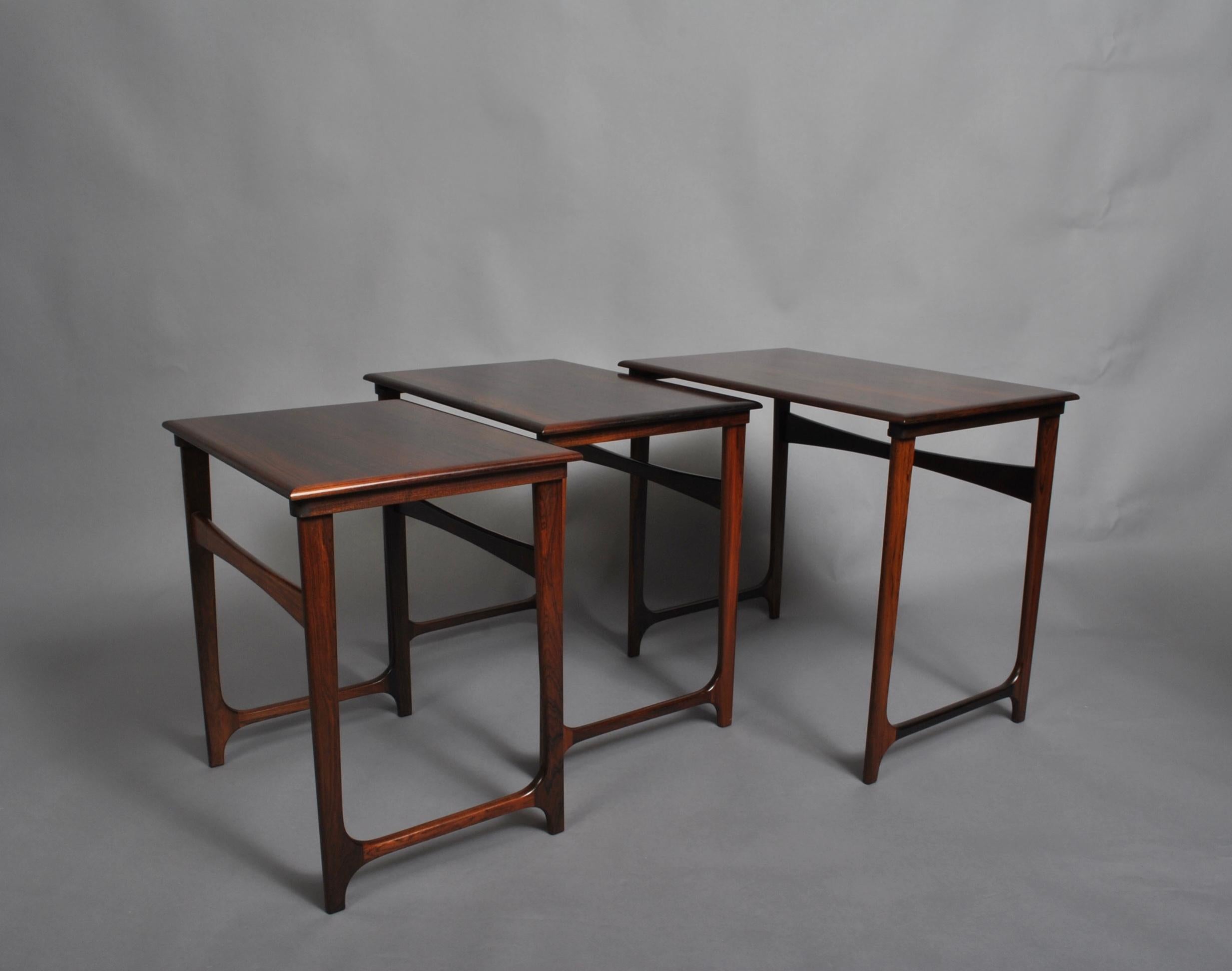 A very fine set of Danish midcentury nesting tables, circa 1950. Manufactured in Denmark by renowned BC Mobler. Superb craftsmanship with curved stretcher joints and wonderful wood grain surfaces. Elegant and practical midcentury design. A rare