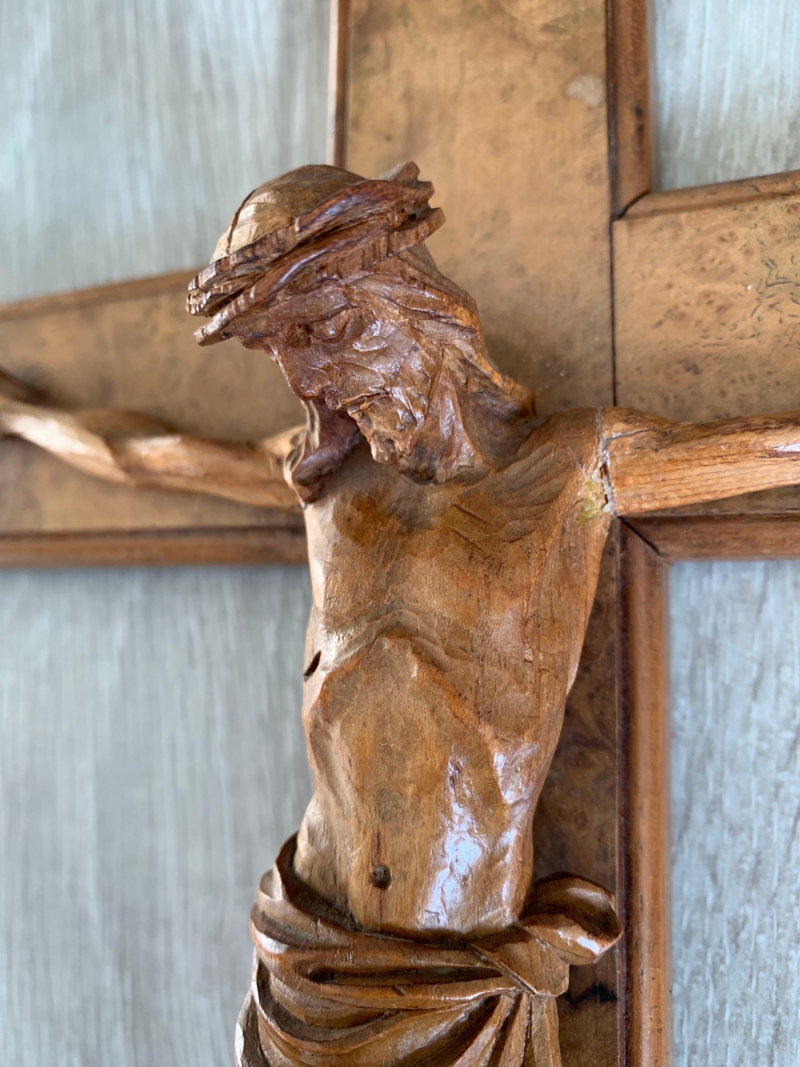Well-crafted and sacred work of religious art. 

This modest size and all hand-carved corpus of Christ is mounted on an oak cross and this fine example is in good condition. The cross is inlaid with a layer of burl walnut and the body of Christ is