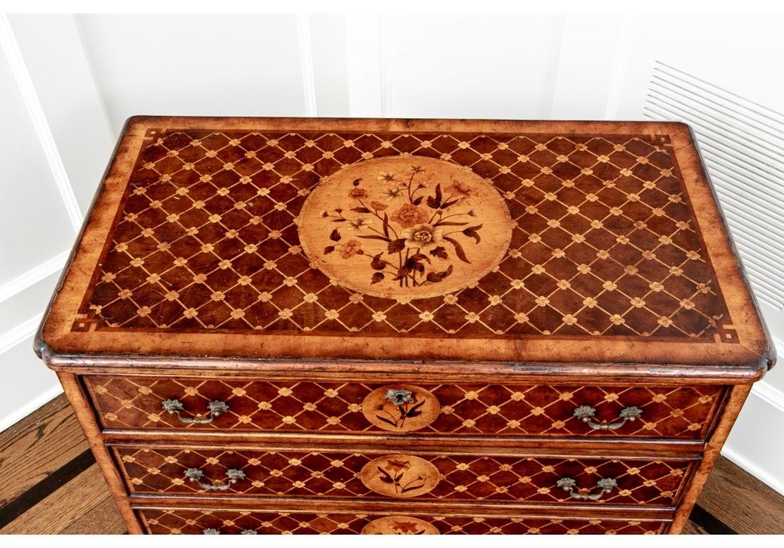 Very fine and well made Marquetry chest in diminutive size Inlaid four drawer chest featuring cross hatch design, canted corners on top with inlaid floral medallions, drawer fronts and sides. Raised on bracket feet with dove-tailed drawer