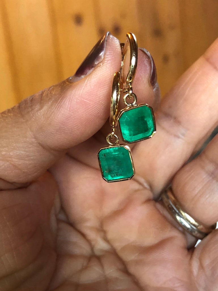 Stylish Dangle Colombian Emerald  Drop Earrings 18K Yellow Gold Bezel Set
These Stunning Earrings Feature a pair of Colombian Emeralds Natural Medium Green, Emerald Cut
Measurement: 8.80mm x 8.47mm, Total Weight 4.90 carats. Bezel set 18K yellow