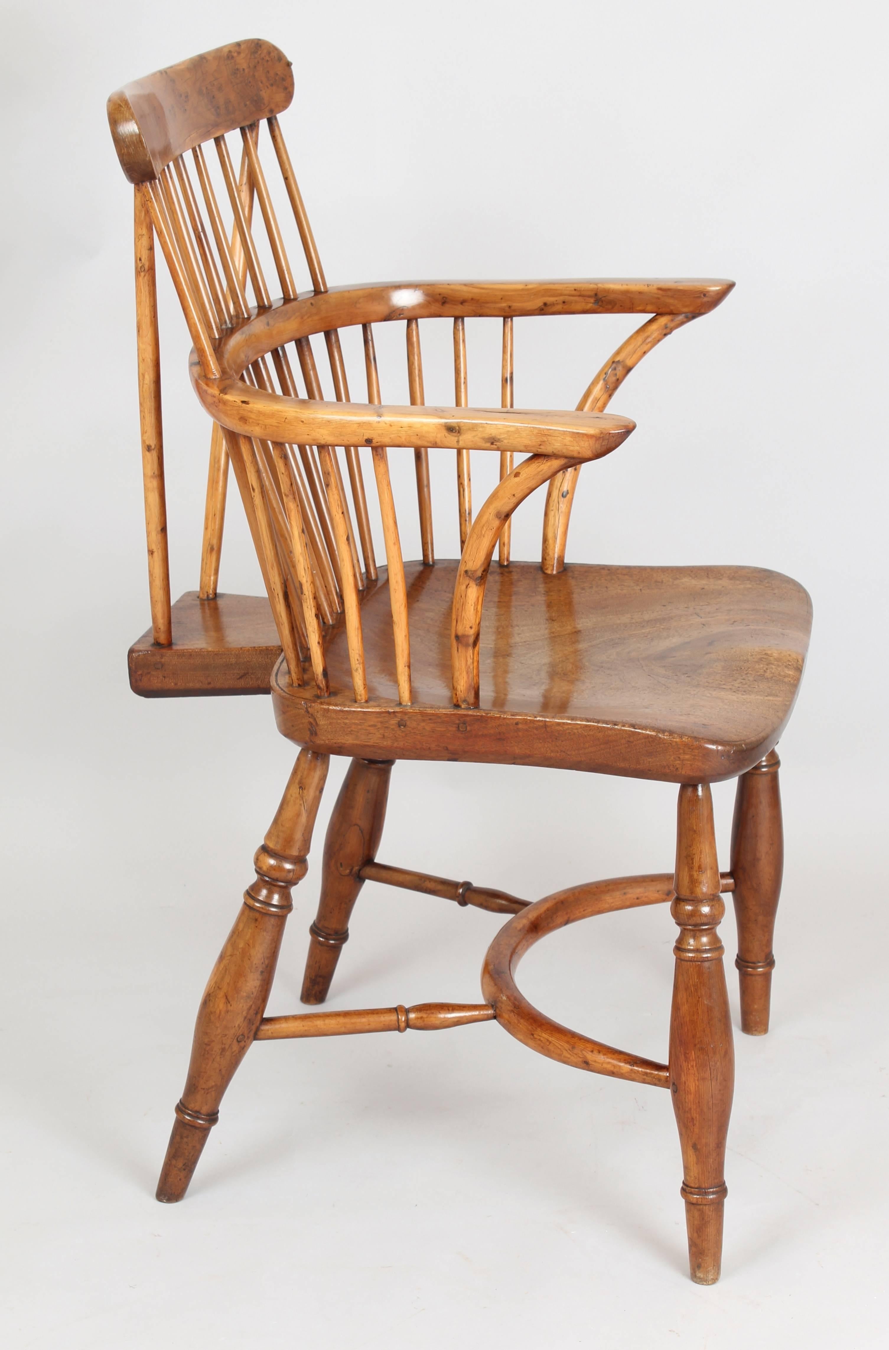 Fine early 19th century yew-wood comb-back Windsor armchair of good colour and patina; the well-figured walnut or fruitwood seat with an unusually bold fan-tail brace, shaped arms on curved supports and turned legs united by a bowed stretcher.