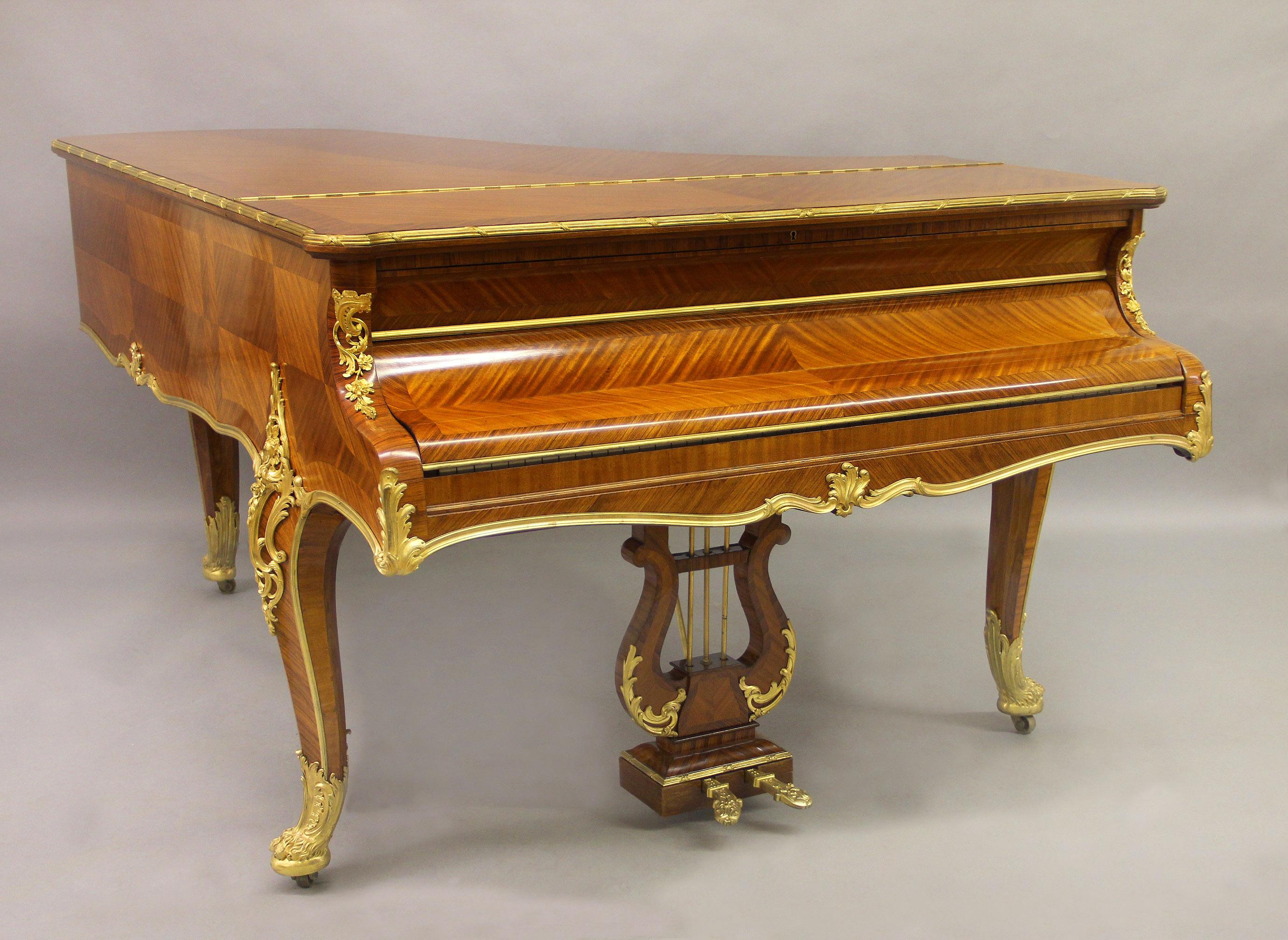 A very fine early 20th century Louis XV style gilt bronze mounted three-leg Grand Erard piano.

By François Linke.

Beautiful quarter veneered case inlaid with cartouche panels surmounted by a hinged lid, with great quality pierced foliate