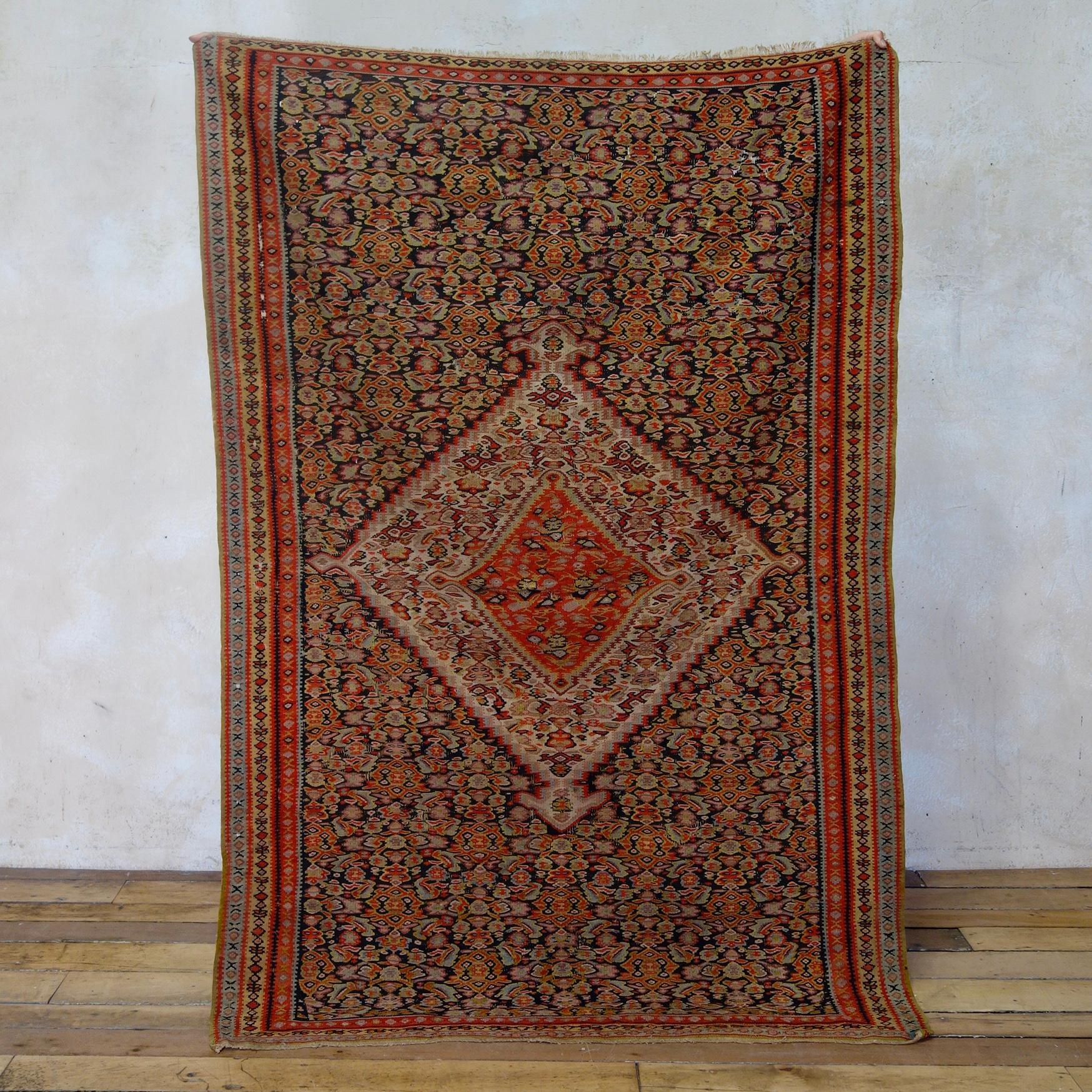 Un beau kilim Senneh, datant de la fin du 19e siècle ou du début du 20e siècle. Un exemple très frappant présentant un grand médaillon central entouré de motifs Heratti bien dessinés et présentant des tons riches.
 
Un kilim fin et durable