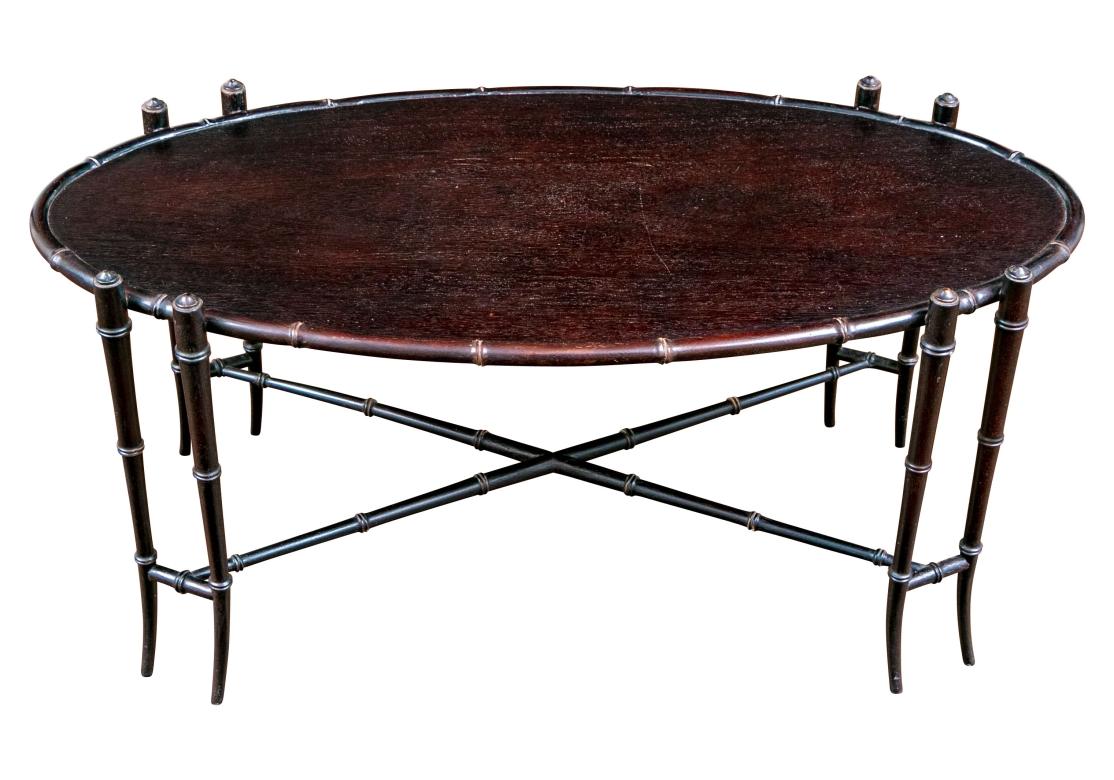 Una mesa de cóctel de bambú sintético muy bien hecha y muy decorativa, fabricada por Hickory Chair. Levantado sobre 8 patas, en cuatro extremos, con un bastidor en forma de X. La mesa ovalada con adornos de imitación de bambú.

Dimensiones: 41,5