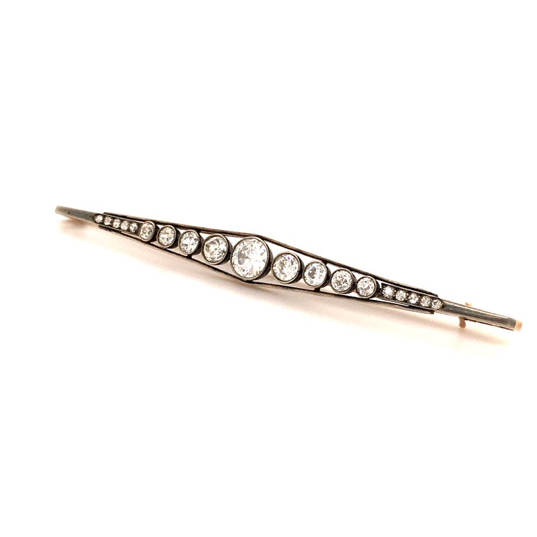 Fine diamond bar pin from the turn of the century. 

Graduated design manufactured in silver on rose gold 14 Kt. Millgriffes set with 1 charming Old-European cut diamond of approximate 0.68 ct, flanked by 18 old-cut diamonds totalling around 1.24