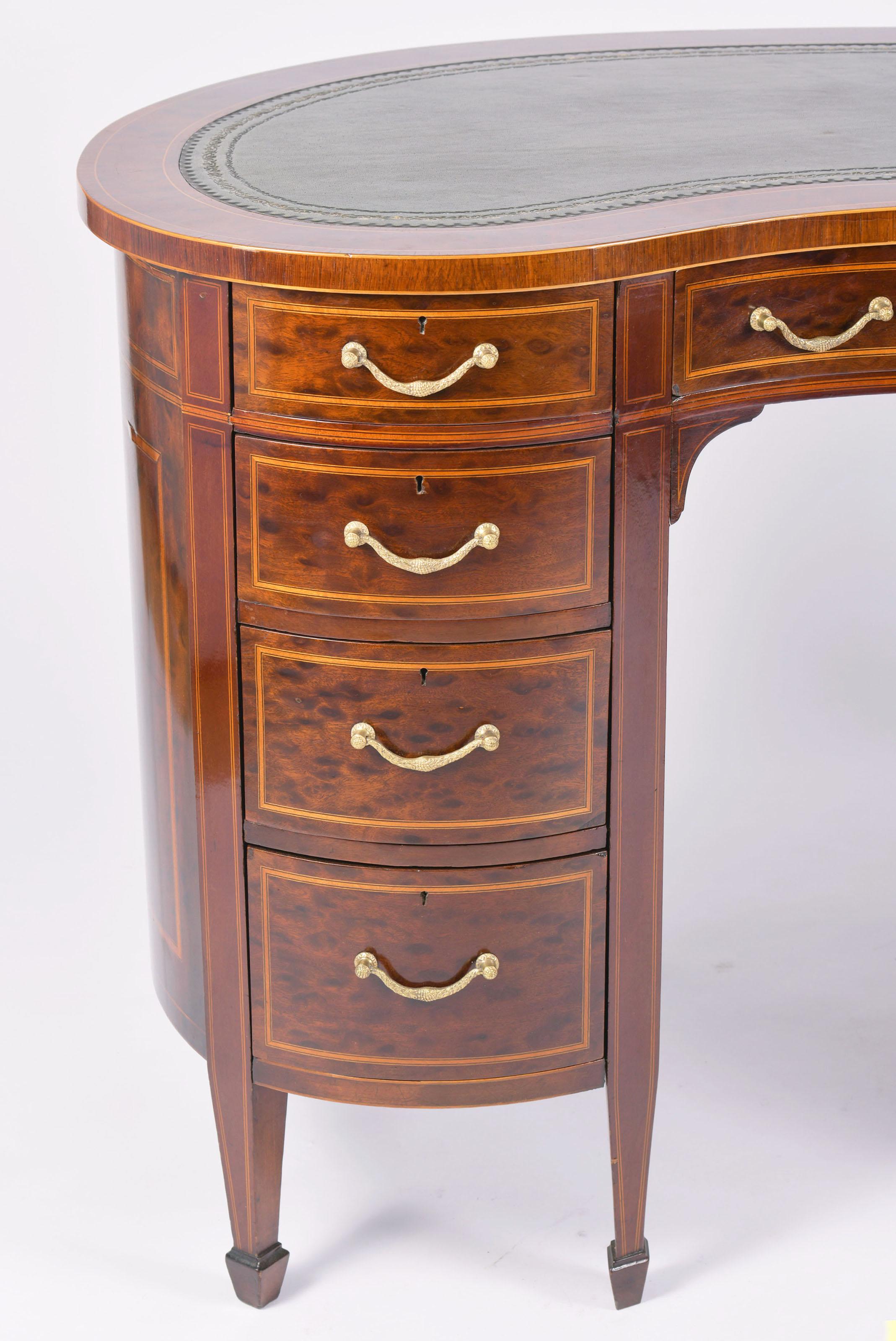 This very fine and attractive Edwardian mahogany shaped desk is inlaid with Boxwood stringing and a tooled leather inset top. The desk features the original hardware and crossbanded satinwood detailing. 
It measures 48 in – 122 cm wide, 23 in – 58