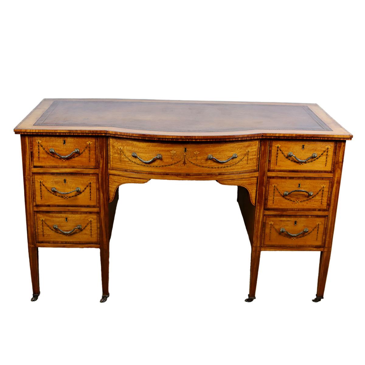An Edwardian Neoclassical Revival satinwood desk. 
An Edwardian Neoclassical Revival satinwood desk, the inset tooled leather writing surface above seven drawers inlaid with bellflower swags. This is beautifully made and is of amazing quality
An