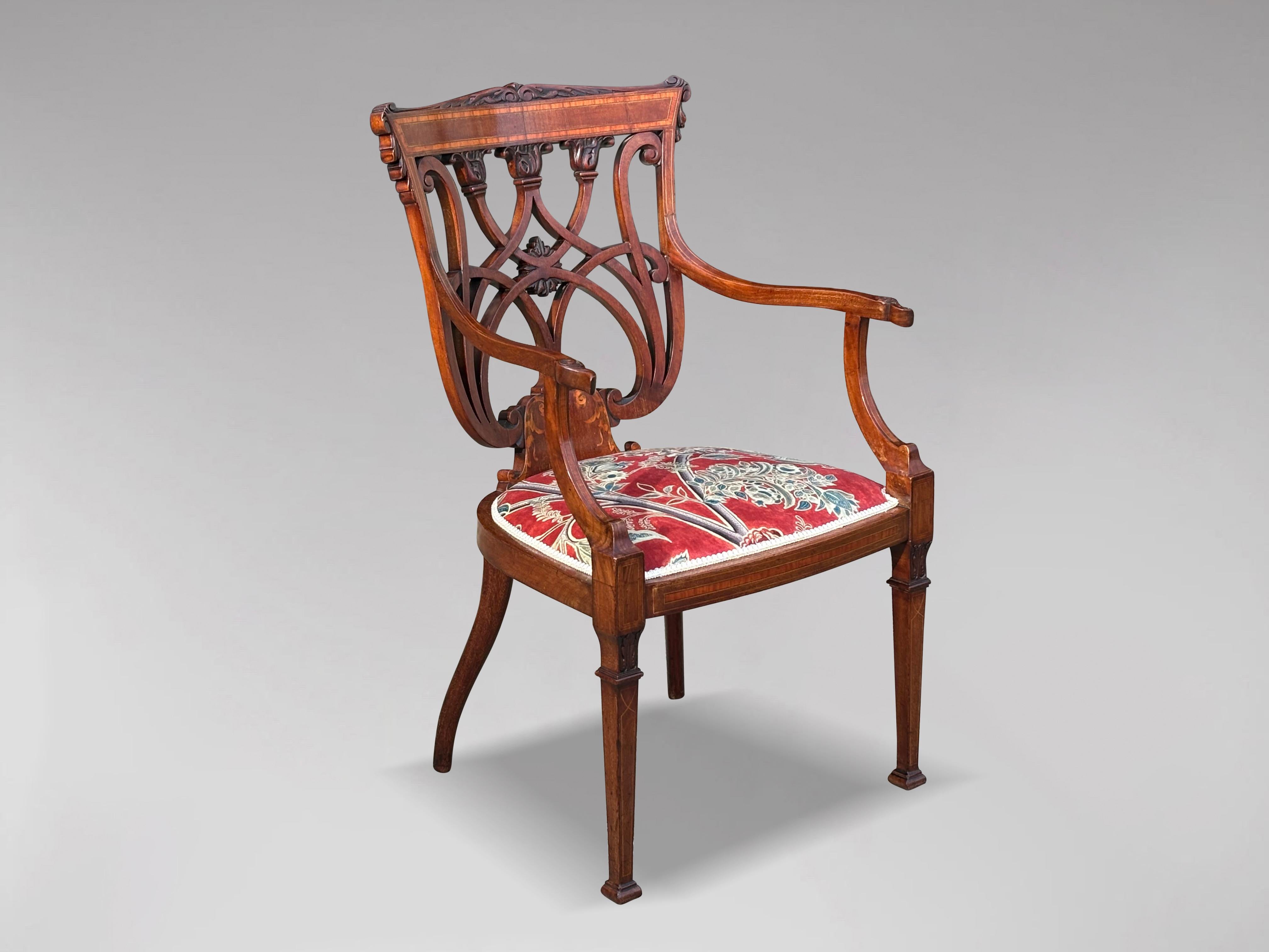 A fine quality antique Edwardian period marquetry inlaid occasional armchair. Made from solid mahogany with a curved rosewood and satinwood inlaid top back rail, above carved pierced fretwork to the back. The back connects to shaped arms, raised on