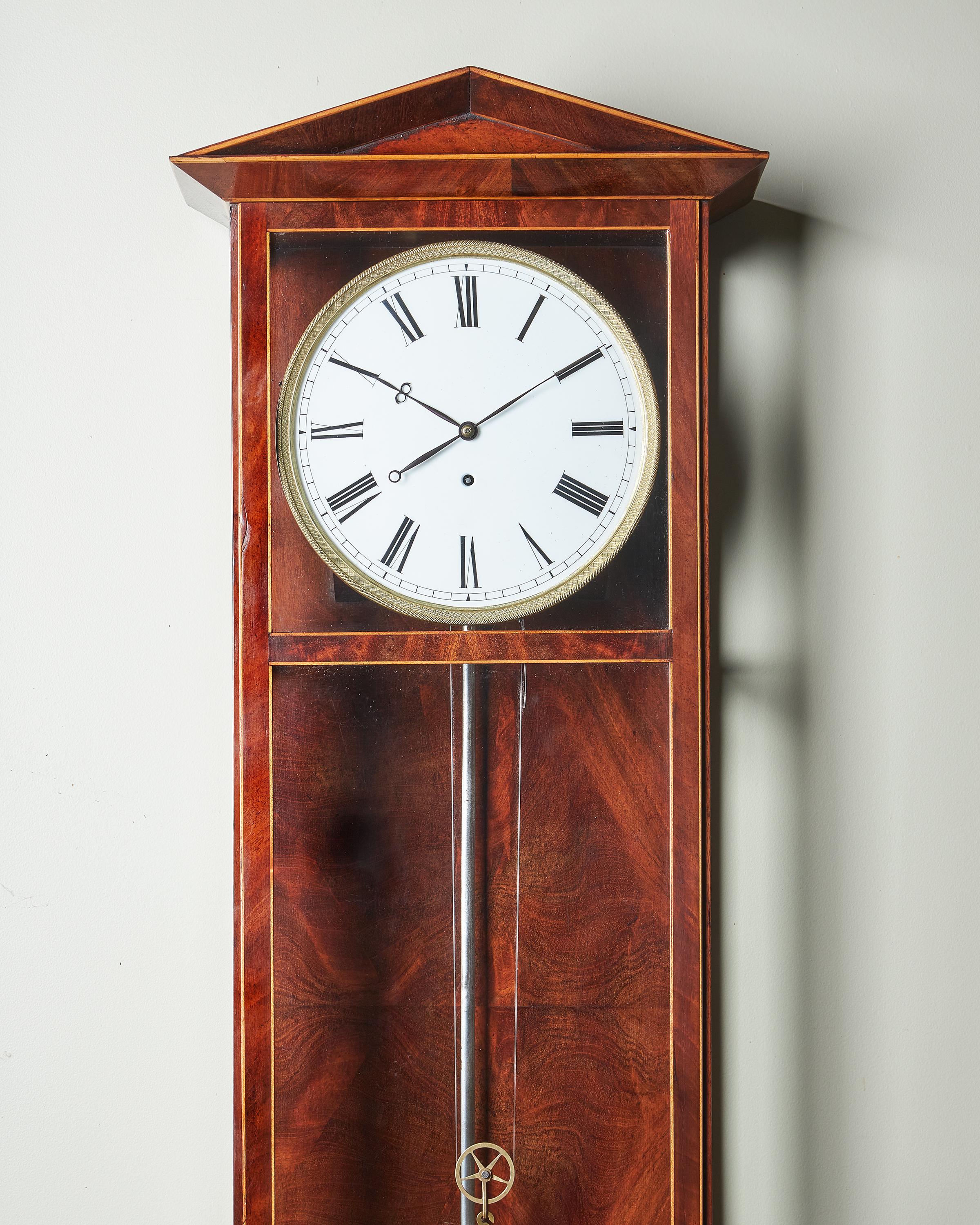 A fine and extremely elegant Vienna regulator of wonderful proportions with a mahogany-veneered and boxwood line inlaid case, c. 1840-50 (German: Dachl-Uhr). The elegant case has a triangular architectural pediment, glazed front door and sides, and